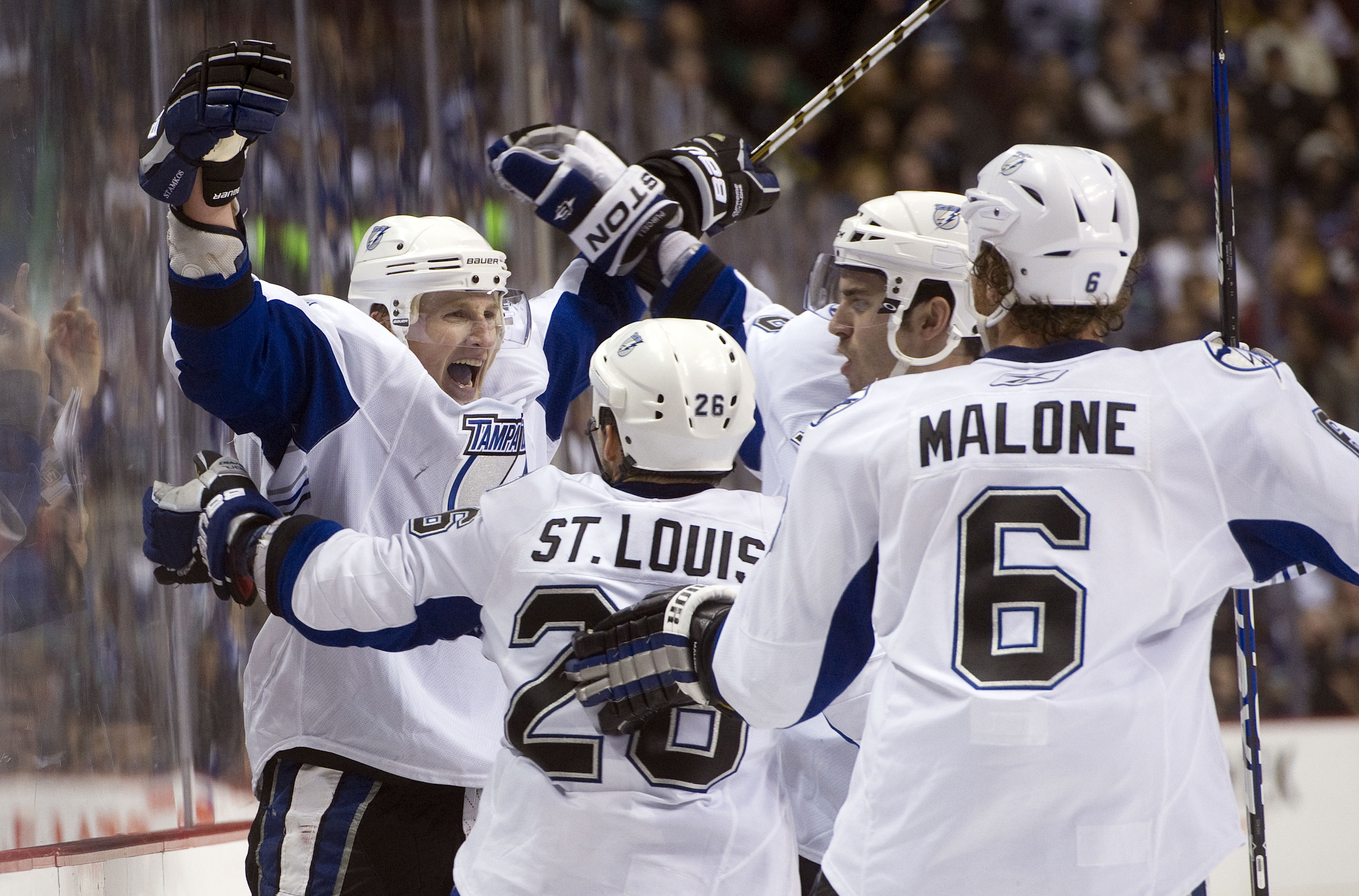 VANCOUVER, CANADA - DECEMBER 11: Steven Stamkos #91 of the Tampa Bay Lightning celebrates with Martin St Louis #26, Ryan Malone #6 and Teddy Purcell #16 after scoring against the Vancouver Canucks in overtime to win 5-4 during NHL action on December 11, 2