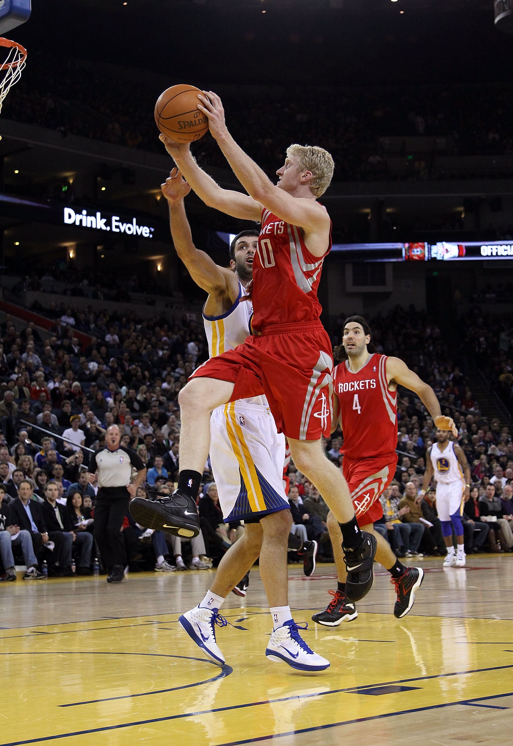 OAKLAND, CA - DECEMBER 20:  Chase Budinger #10 of the Houston Rockets shoots over Vladimir Radmanovic #77 of the Golden State Warriors at Oracle Arena on December 20, 2010 in Oakland, California. NOTE TO USER: User expressly acknowledges and agrees that,