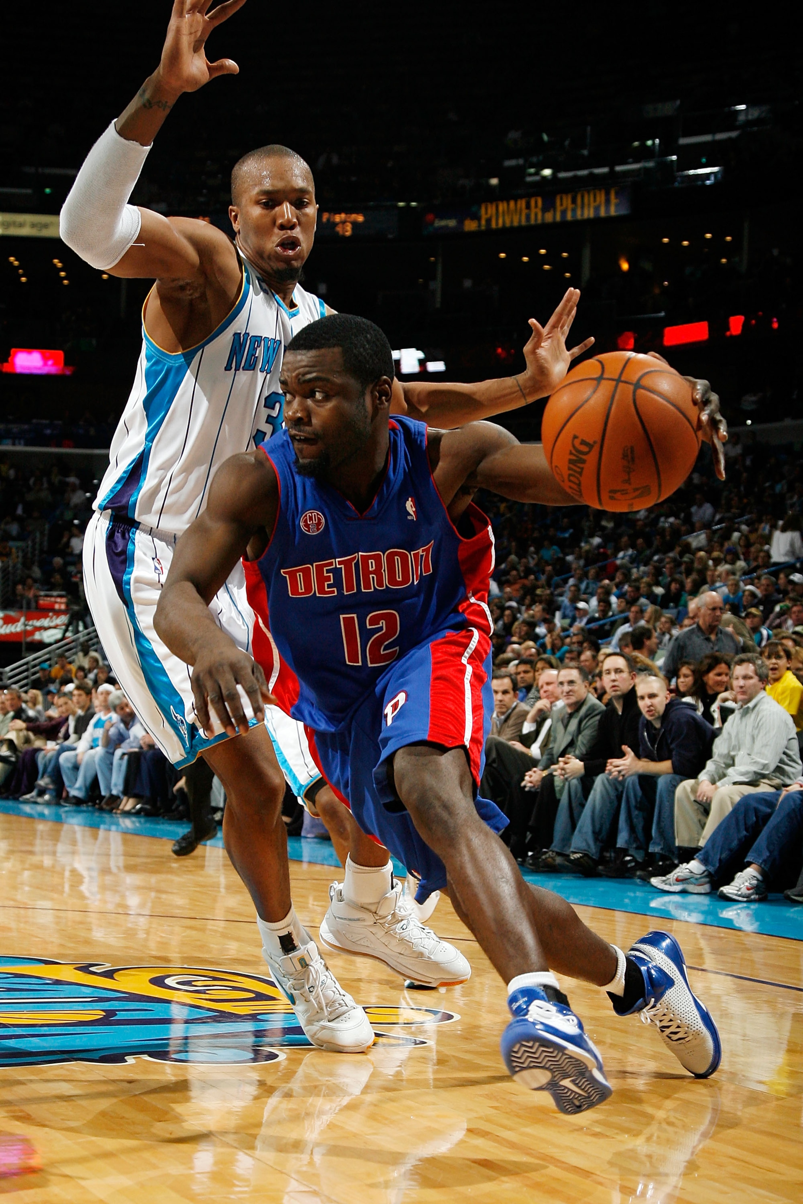 NEW ORLEANS - DECEMBER 16:  Will Bynum #12 of the Detroit Pistons drives the ball around David West #30 of the New Orleans Hornets at New Orleans Arena on December 16, 2009 in New Orleans, Louisiana.  The Hornets defeated the Pistons 95-87. NOTE TO USER: