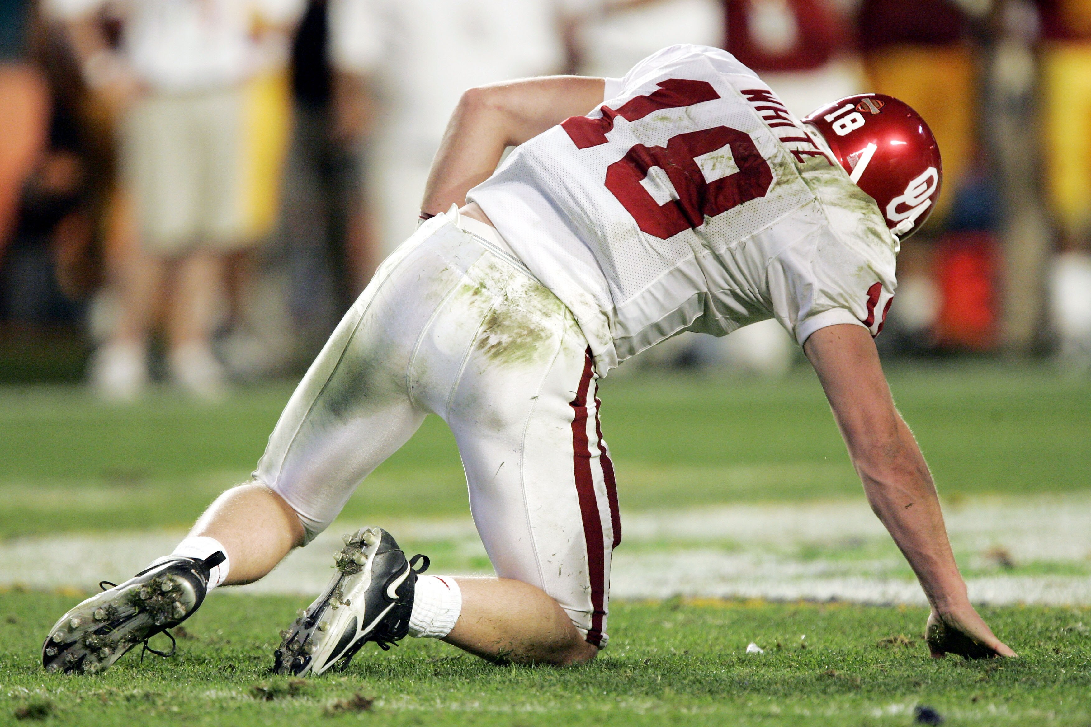 MIAMI - JANUARY 4:  Quarterback Jason White #18 of the Oklahoma Sooners gets up off the ground after being hit hard by the USC Trojans defense in the third quarter during the FedEx Orange Bowl 2005 National Championship on January 4, 2005 at Pro Player St
