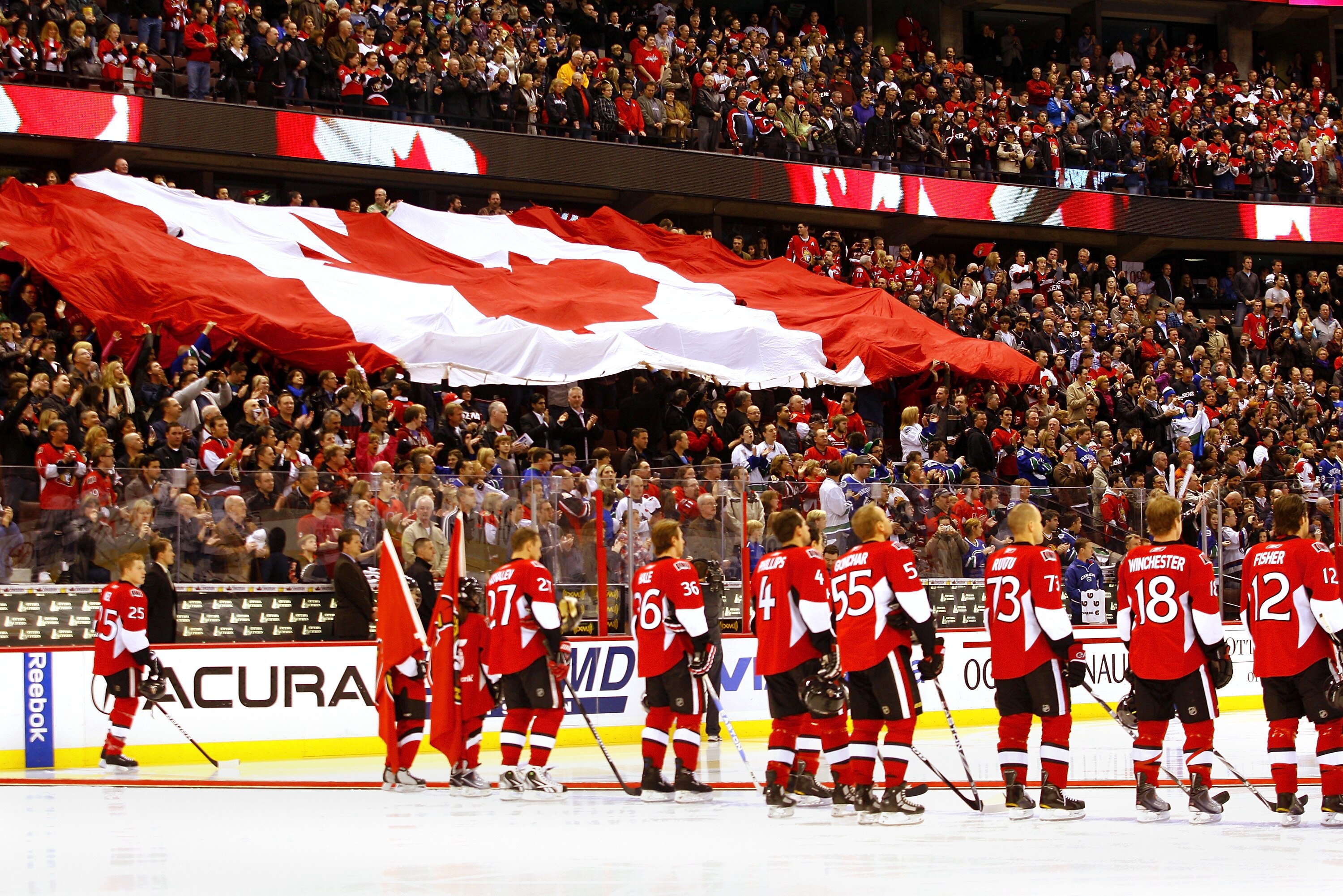OTTAWA, CANADA - NOVEMBER 11:  The Ottawa Senators stand at the blue line as the Canadian flag passes through the crowd prior to a game against the Vancouver Canucks on Remembrance Day at Scotiabank Place on November 11, 2010 in Ottawa, Ontario, Canada.