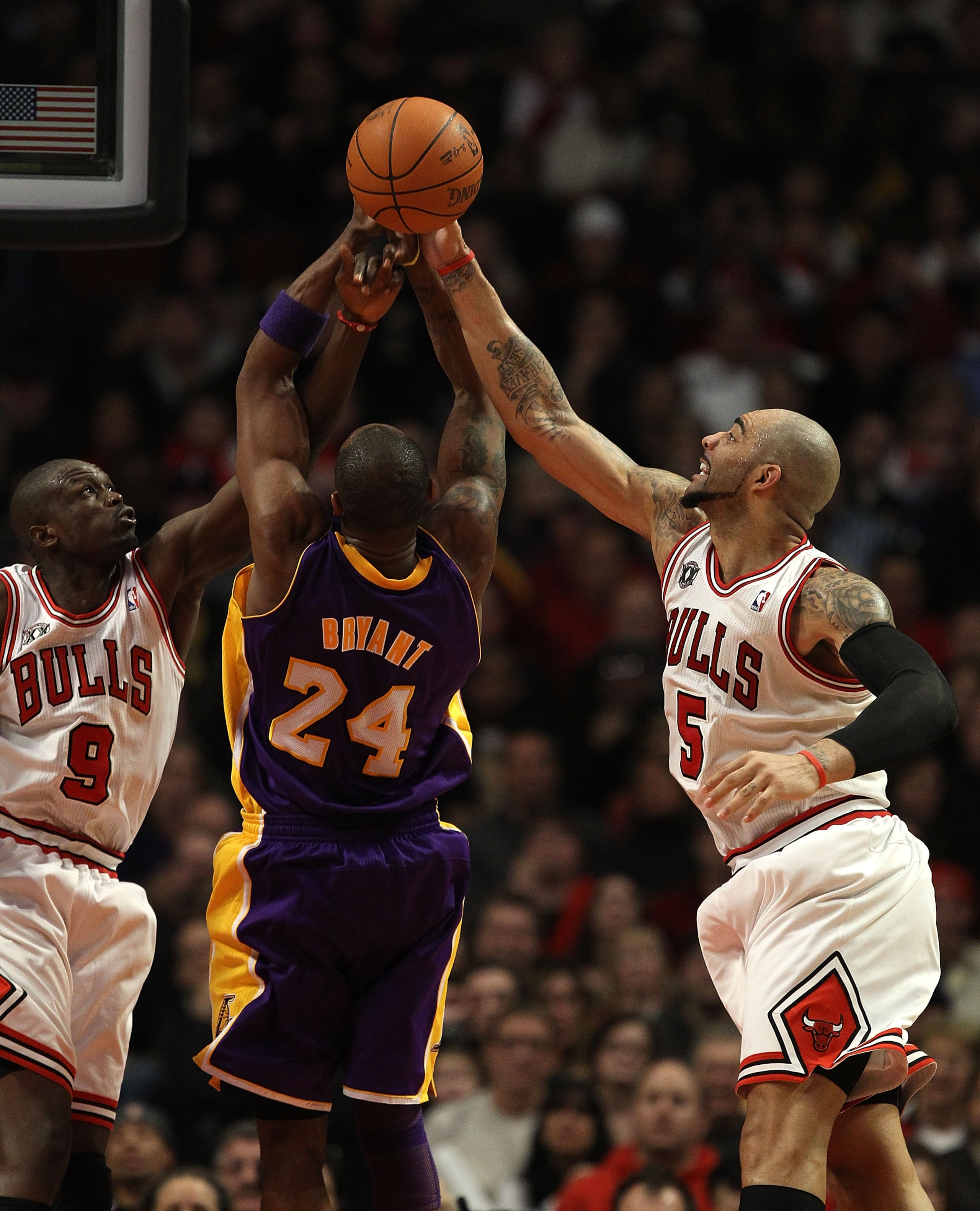 CHICAGO, IL - DECEMBER 10: Carlos Boozer #5 of the Chicago Bulls knocks the ball away from Kobe Bryant #24 of the Los Angeles Lakers as Loul Deng #9 also defends at the United Center on December 10, 2010 in Chicago, Illinois. The Bulls defeated the Lakers