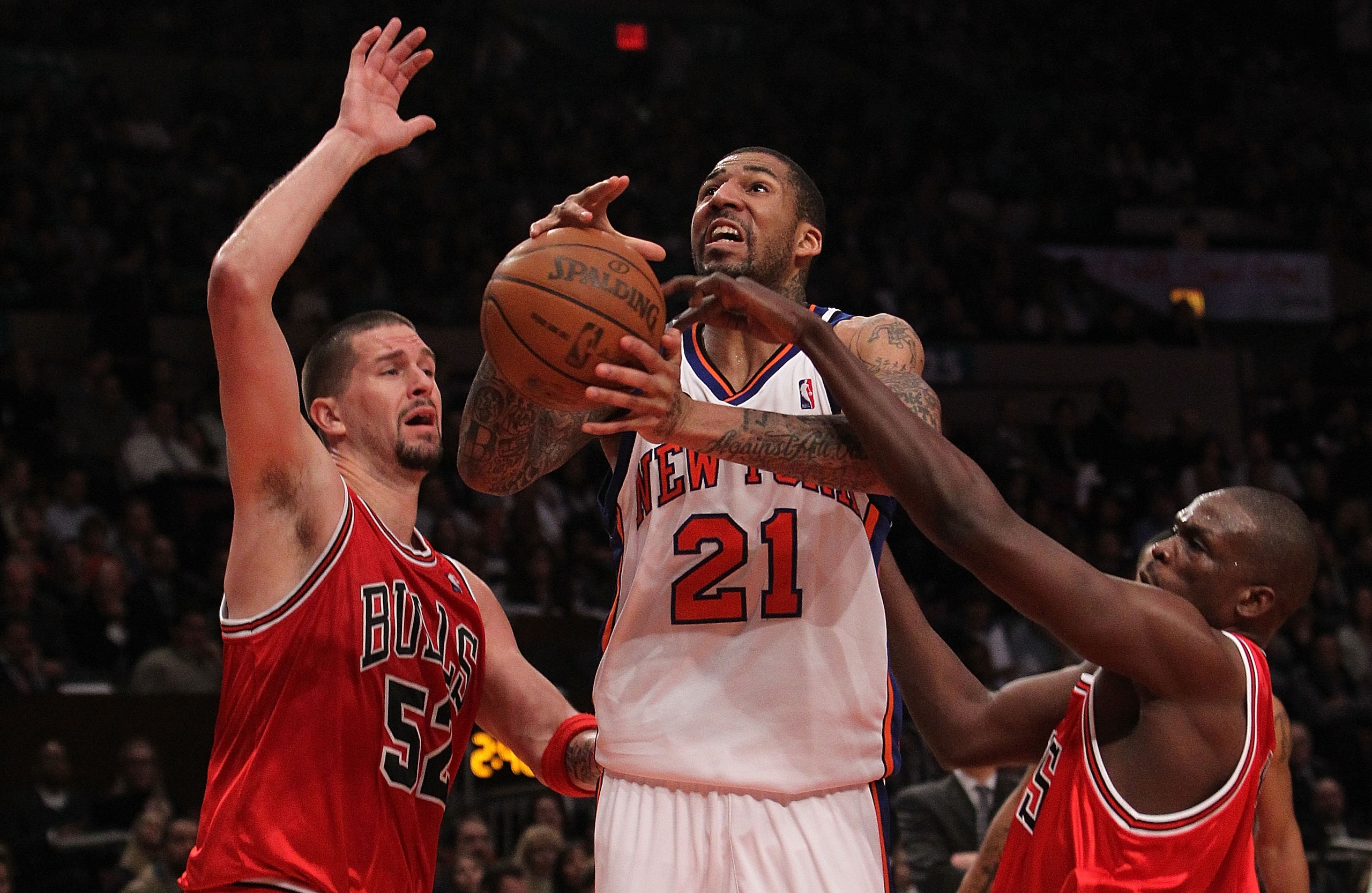 NEW YORK - FEBRUARY 17: Wilson Chandler #21 of the New York Knicks goes to the basket between Brad Miller #52 and Luol Deng #9 of the Chicago Bulls at Madison Square Garden on February 17, 2010 in New York, New York. NOTE TO USER: User expressly acknowled