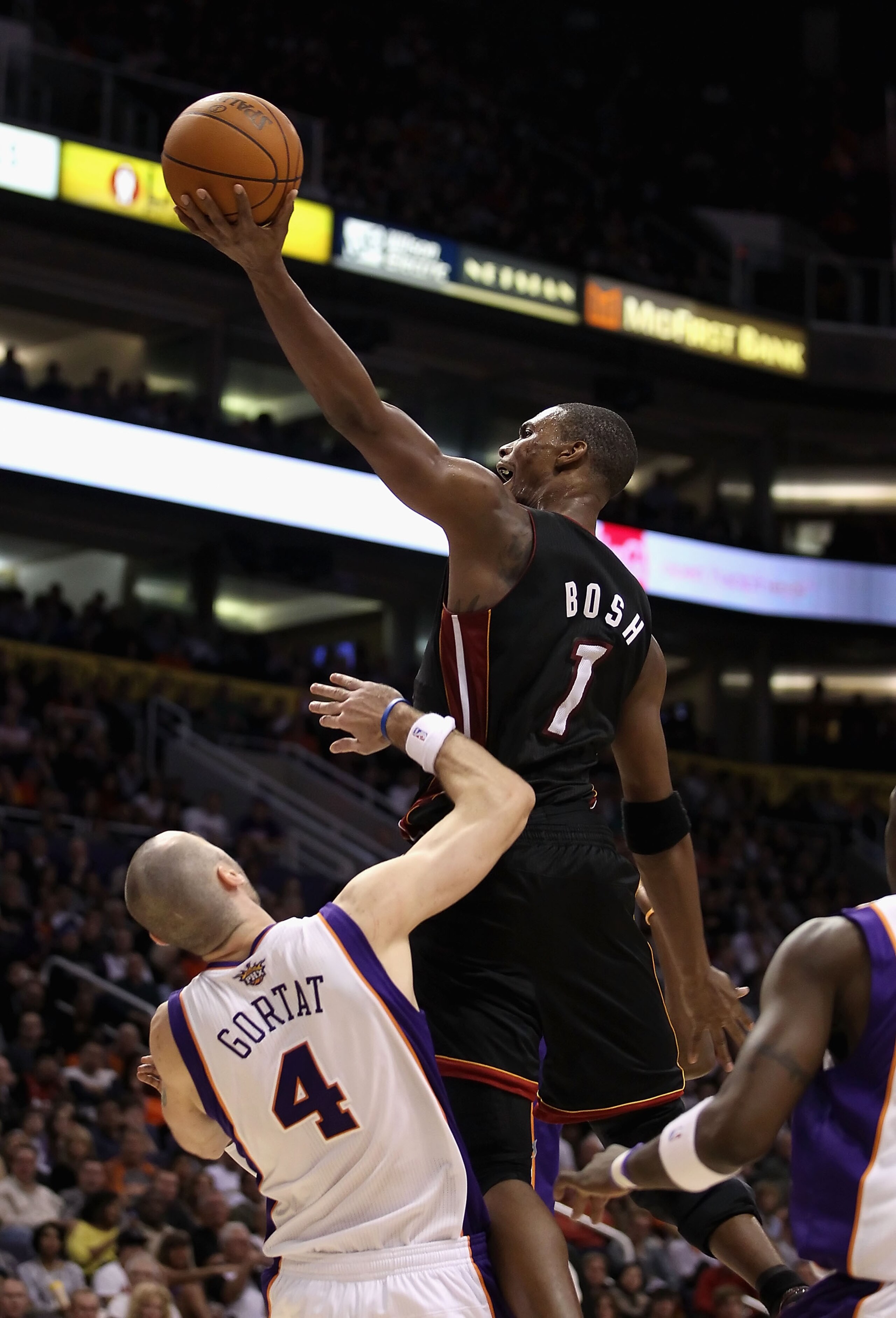 PHOENIX - DECEMBER 23:  Chris Bosh #1 of the Miami Heat puts up a shot over Marcin Gortat #4 of the Phoenix Suns during the NBA game at US Airways Center on December 23, 2010 in Phoenix, Arizona.  The Heat defeated the Suns 95-83. NOTE TO USER: User expre