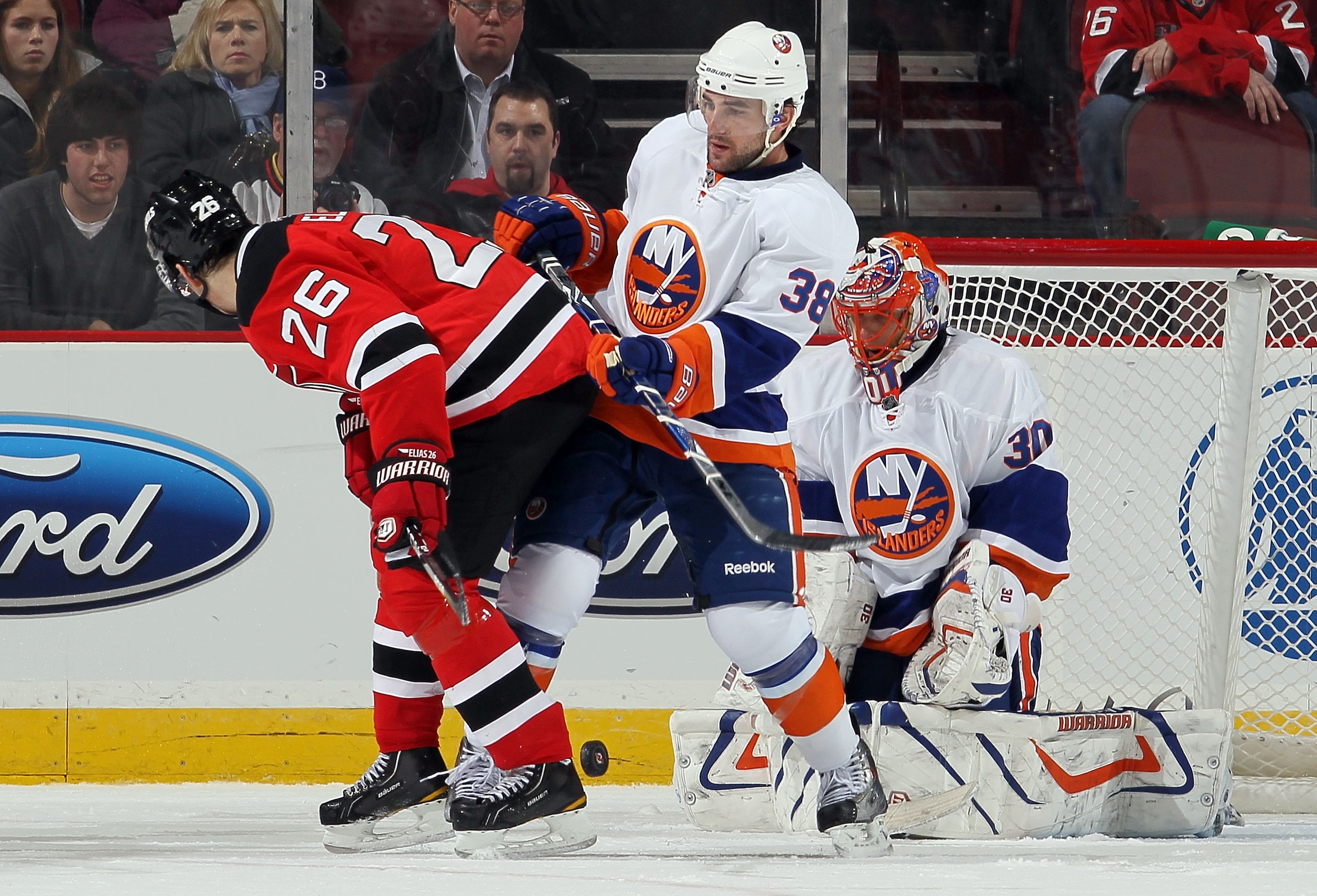 NEWARK, NJ - DECEMBER 23:  Dwayne Roloson #30 and Jack Hillen #38 of the New York Islanders defend against Patrik Elias #26 of the New Jersey Devils at the Prudential Center on December 23, 2010 in Newark, New Jersey.  (Photo by Jim McIsaac/Getty Images)