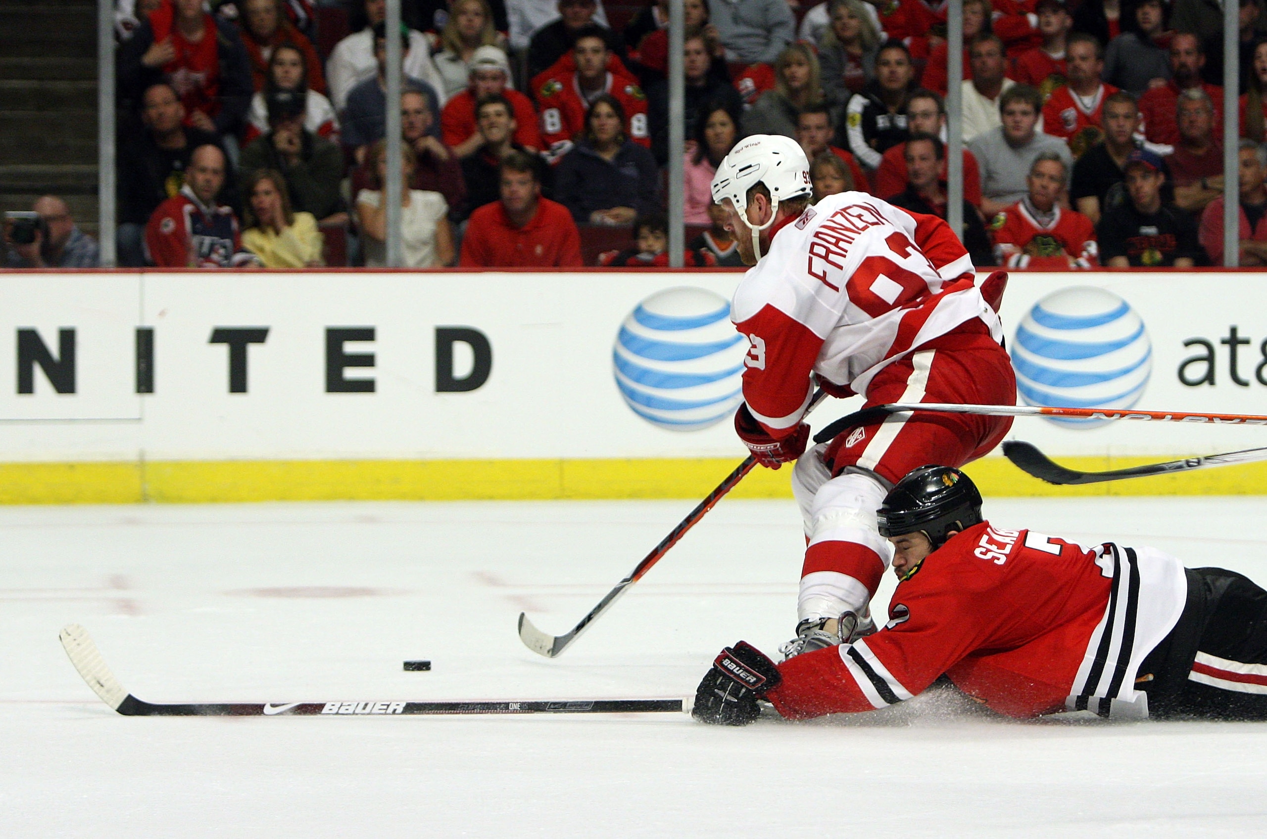 CHICAGO - MAY 24:  Johan Franzen #93 of the Detroit Red Wings skates with the puck as Brent Seabrook #7 the Chicago Blackhawks slides head first down the ice behind him during Game Four of the Western Conference Championship Round of the 2009 Stanley Cup