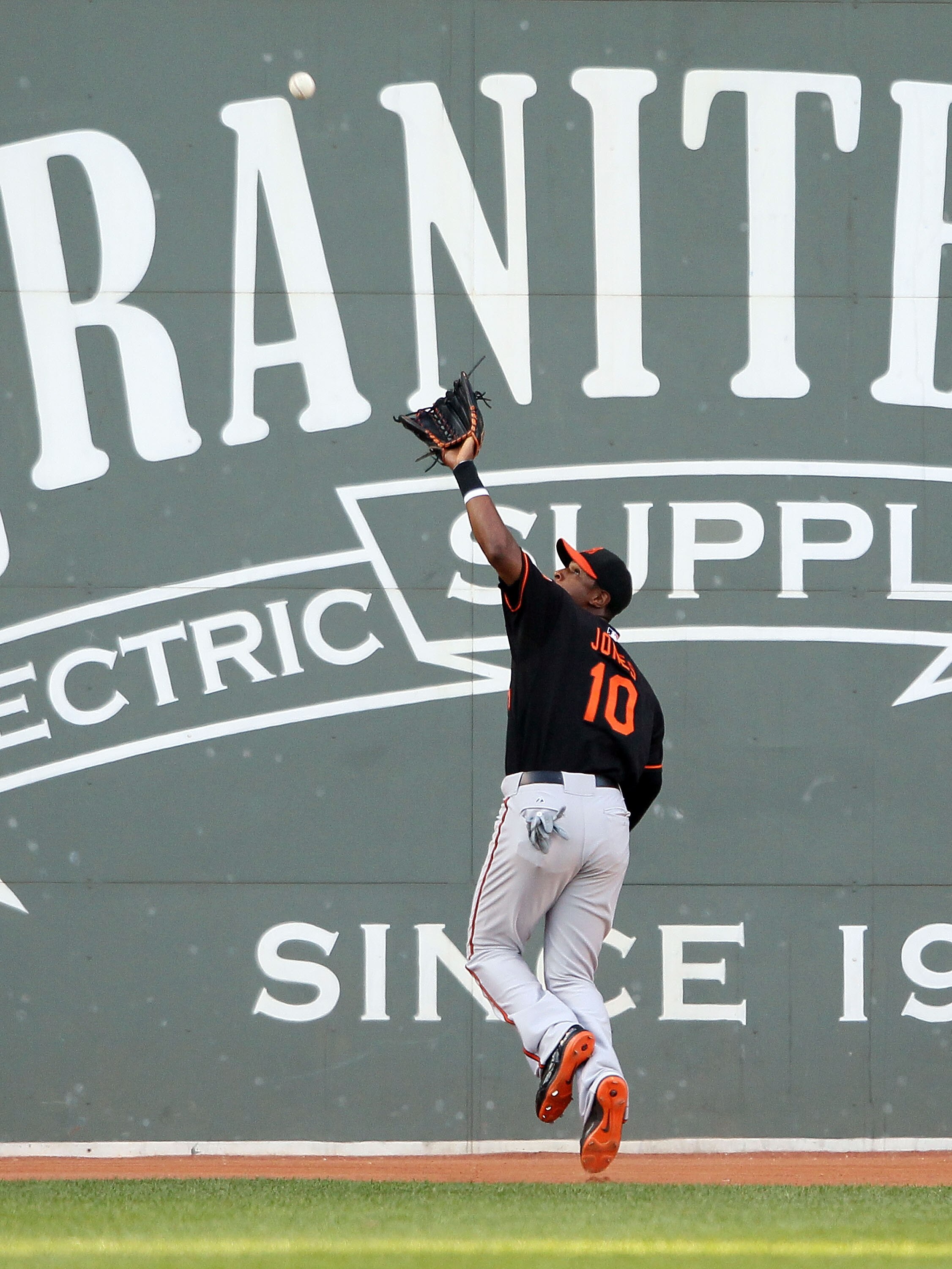 BOSTON - JULY 02:  Adam Jones #10 of the Baltimore Orioles makes the catch for the out on a hit by Eric Patterson of the Boston Red Sox on July 2, 2010 at Fenway Park in Boston, Massachusetts.  (Photo by Elsa/Getty Images)