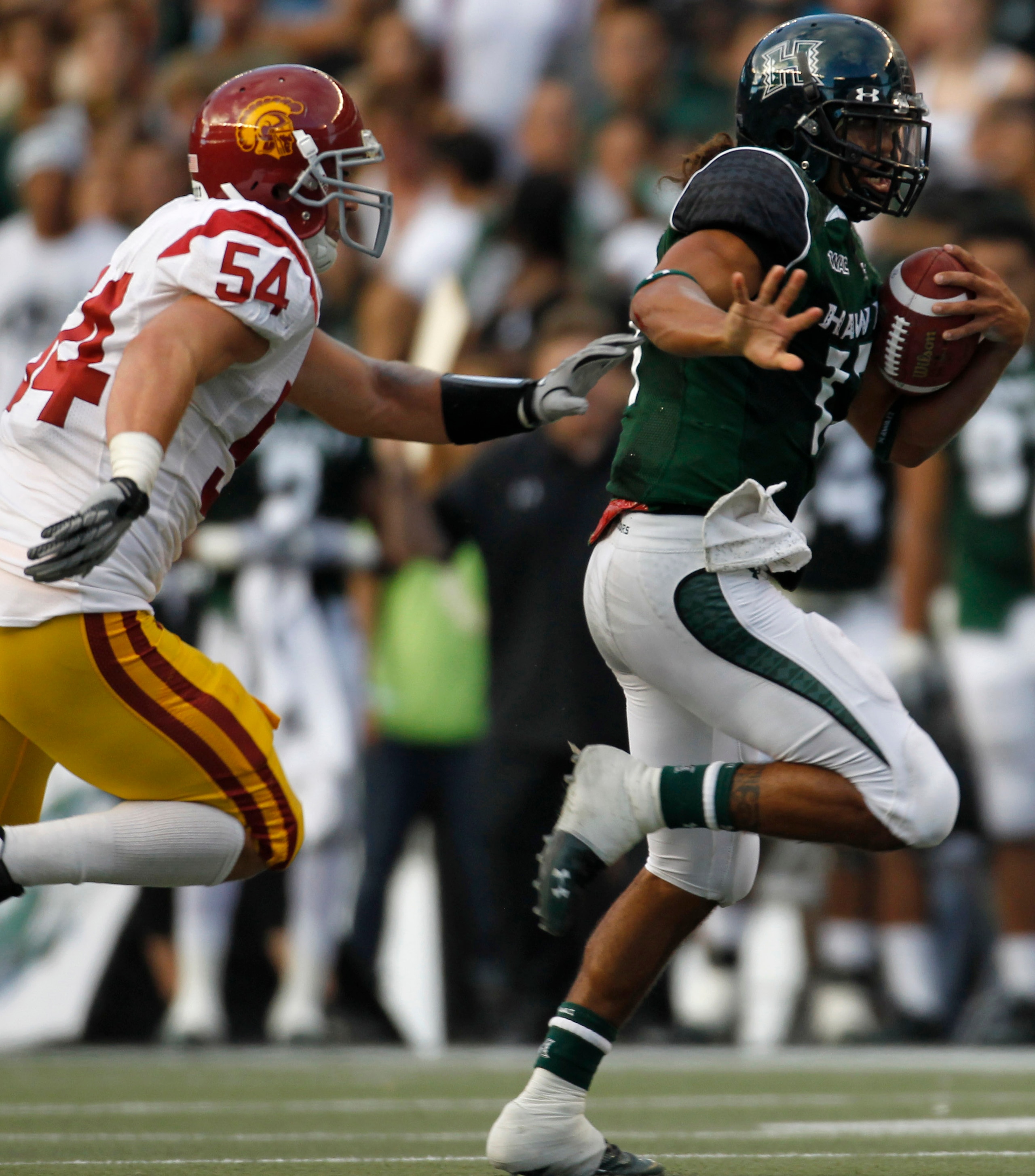 HONOLULU - SEPTEMBER 02: Quarterback Bryant Moniz #17 of the University of Hawaii Warriors is chased by Chris Galippo #54 of the University of Southern California Trojans as he carries the ball during first half action against the University of Southern C