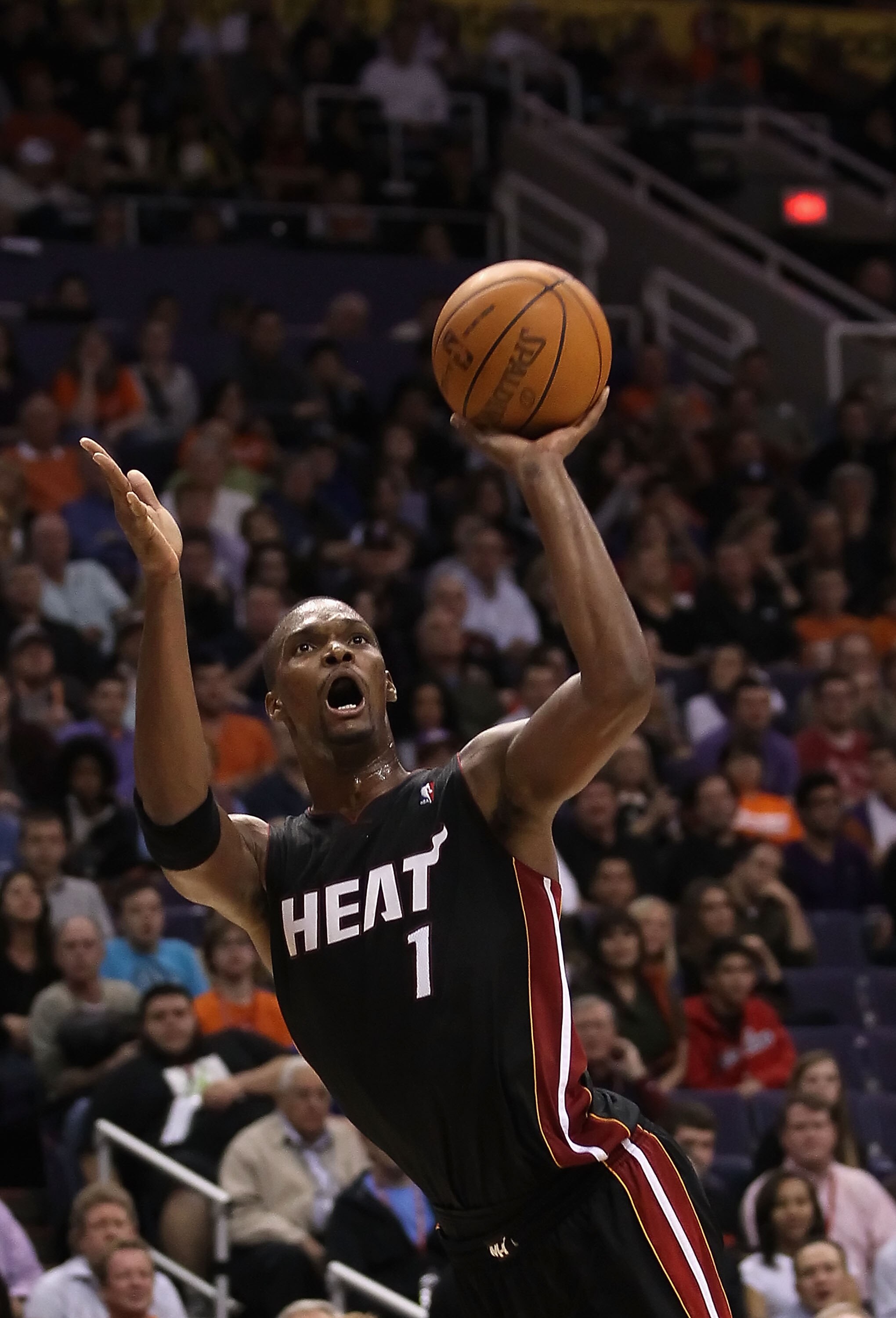 PHOENIX - DECEMBER 23:  Chris Bosh #1 of the Miami Heat puts up a shot during the NBA game against the Phoenix Suns at US Airways Center on December 23, 2010 in Phoenix, Arizona. The Heat defeated the Suns 95-83.  NOTE TO USER: User expressly acknowledges