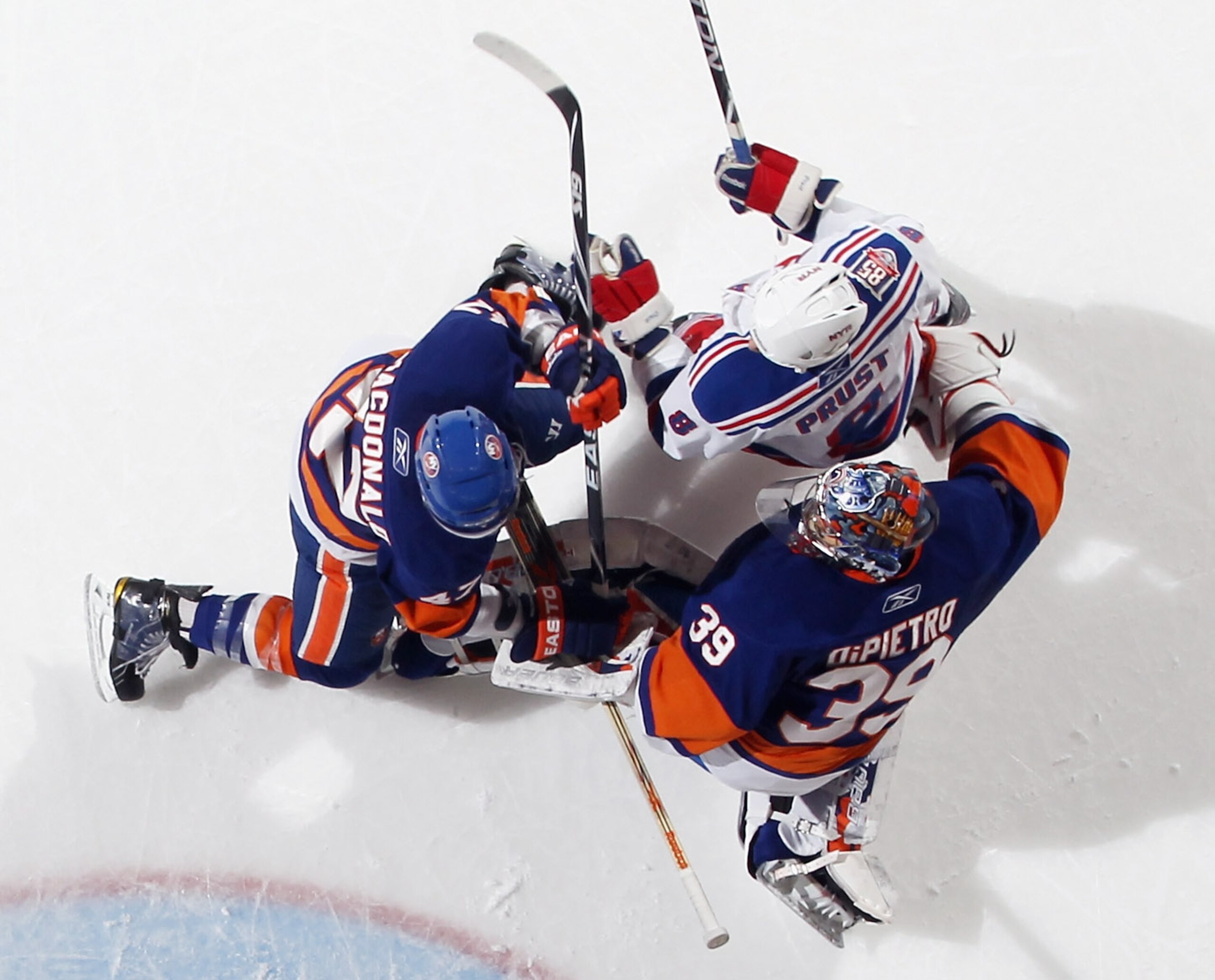 UNIONDALE, NY - DECEMBER 02:  Rick DiPietro #39  and Andrew MacDonald #47 of the New York Islanders defend against Brandon Prust #8 of the New York Rangers at the Nassau Coliseum on December 2, 2010 in Uniondale, New York.  (Photo by Bruce Bennett/Getty I