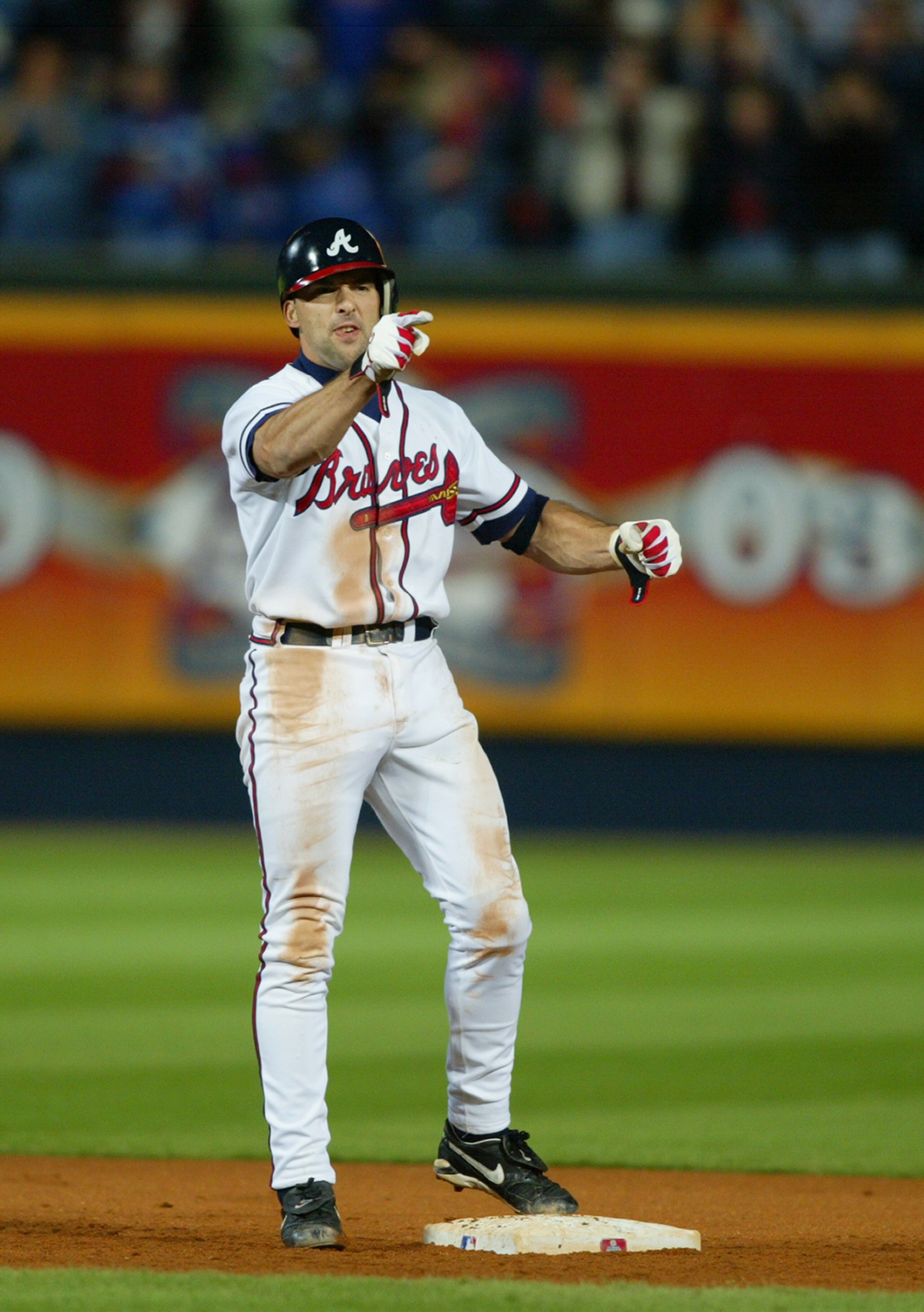 ATLANTA - OCTOBER 1: Mark DeRosa #16 of the Atlanta Braves points to the dugout after hitting a double to drive in the winning run against the Chicago Cubs in the eighth inning of Game 2 of the National League Division Series on October 1, 2003 at Turne ATLANTA - OCTOBER 1: Mark DeRosa #16 of the Atlanta Braves points to the dugout after hitting a double to drive in the winning run against the Chicago Cubs in the eighth inning of Game 2 of the National League Division Series on October 1, 2003 at Turne