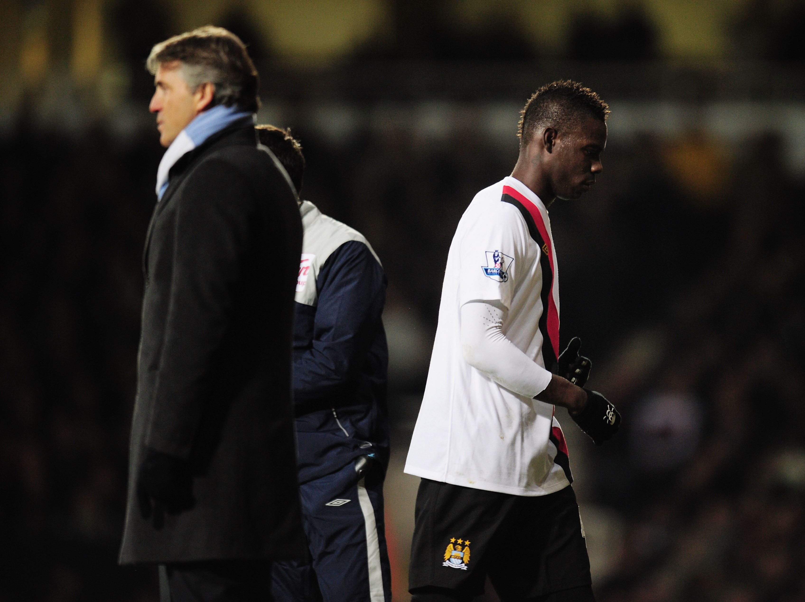 LONDON, UNITED KINGDOM - DECEMBER 11:  Mario Balotelli (R) of Manchester City walks past his manager Roberto Mancini (L) on the touchline as he is subsituted during the Barclays Premier League match between West Ham United and Manchester City at Upton Par