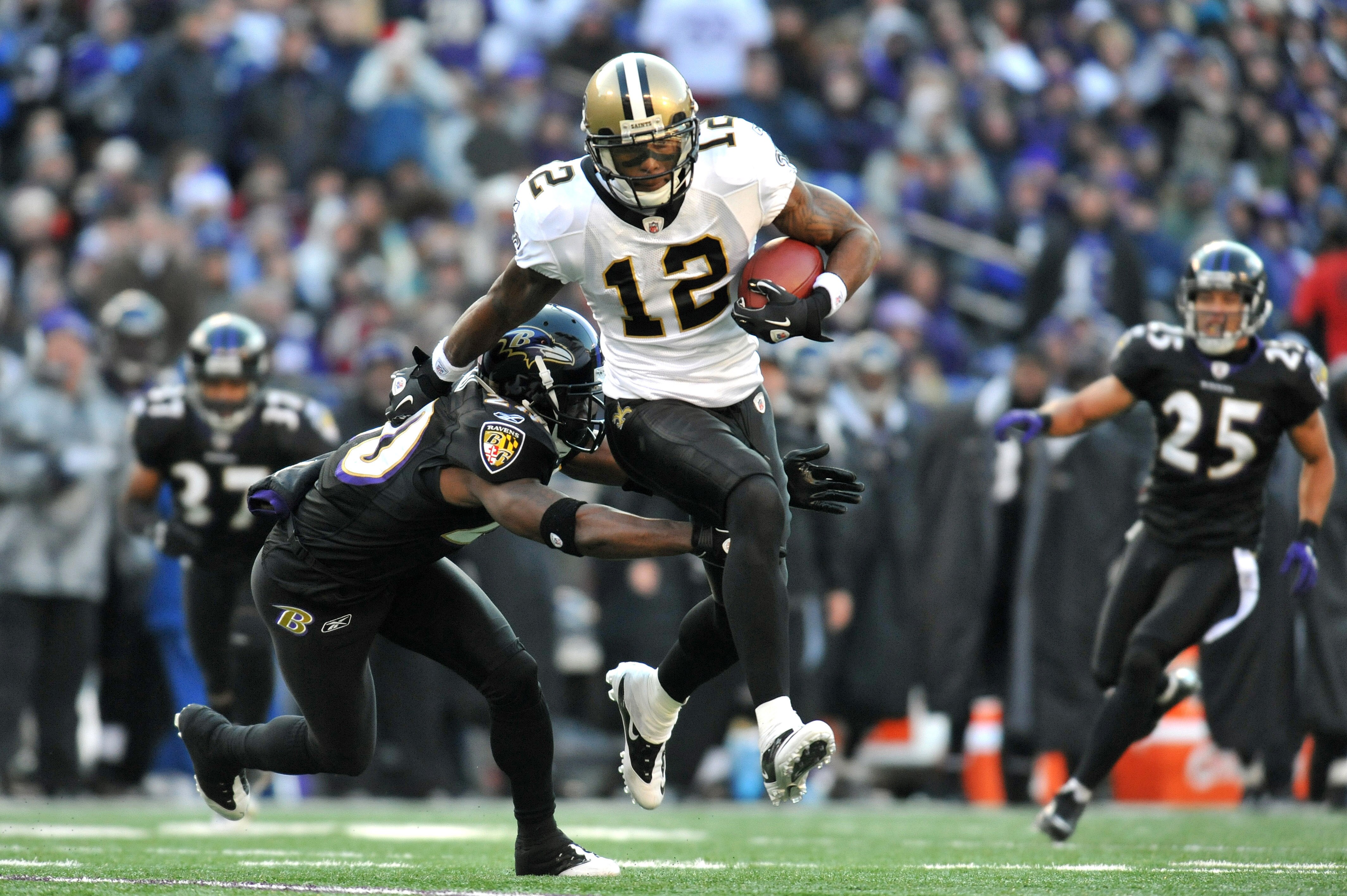 BALTIMORE, MD - DECEMBER 19:  Marques Colston #12 of the New Orleans Saints runs the ball while being defended by Ed Reed #20 of the Baltimore Ravens  at M&T Bank Stadium on December 19, 2010 in Baltimore, Maryland. The Ravens defeated the Saints 30-24. (