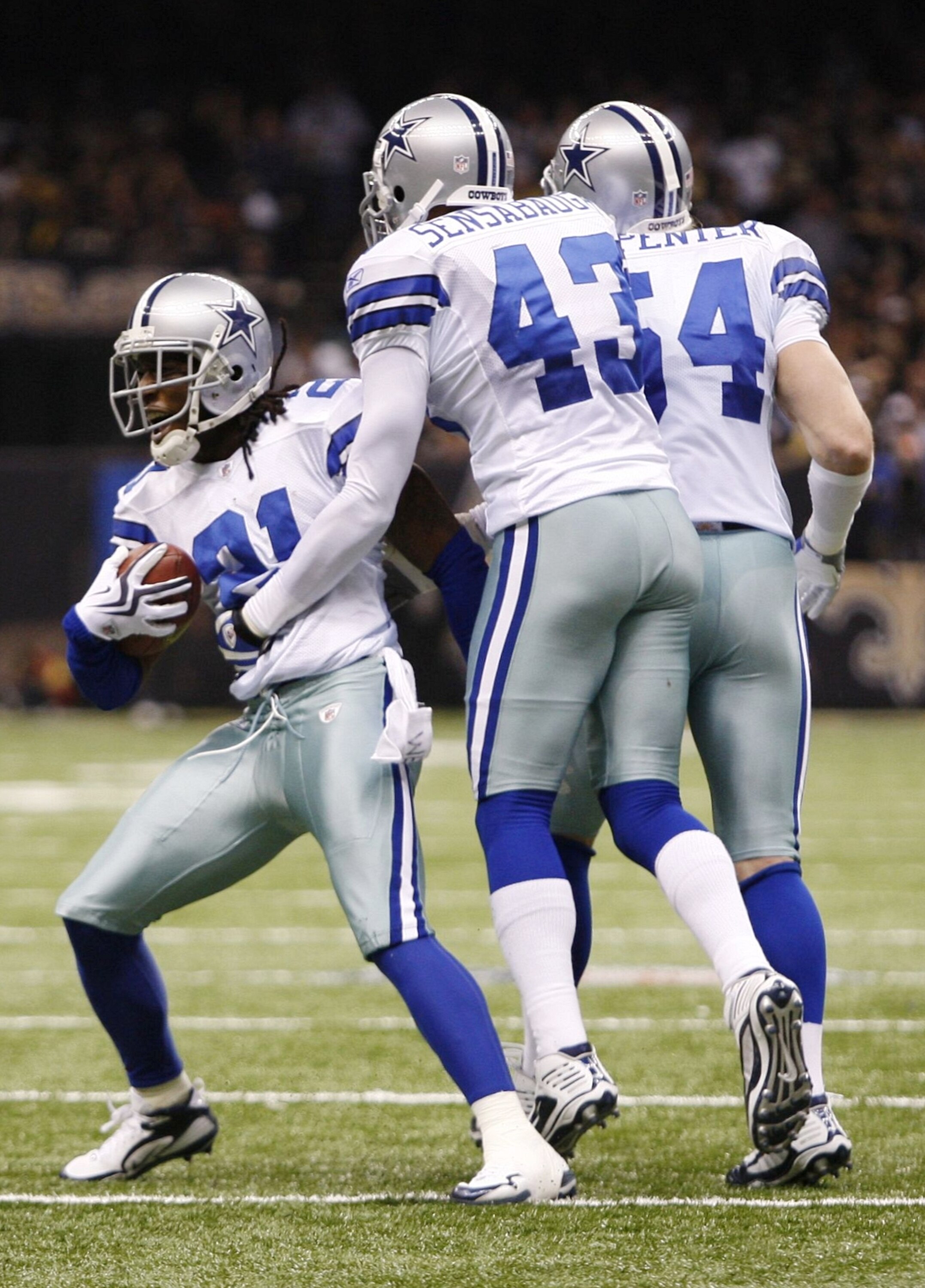 NEW ORLEANS - DECEMBER 19: (L-R) Cornerback Mike Jenkins #21, safety Gerald Sensabaugh #43 and linebacker Bobby Carpenter #54 of the Dallas Cowboys celebrate after an interception against the New Orleans Saints at Louisiana Superdome on December 19, 2009 