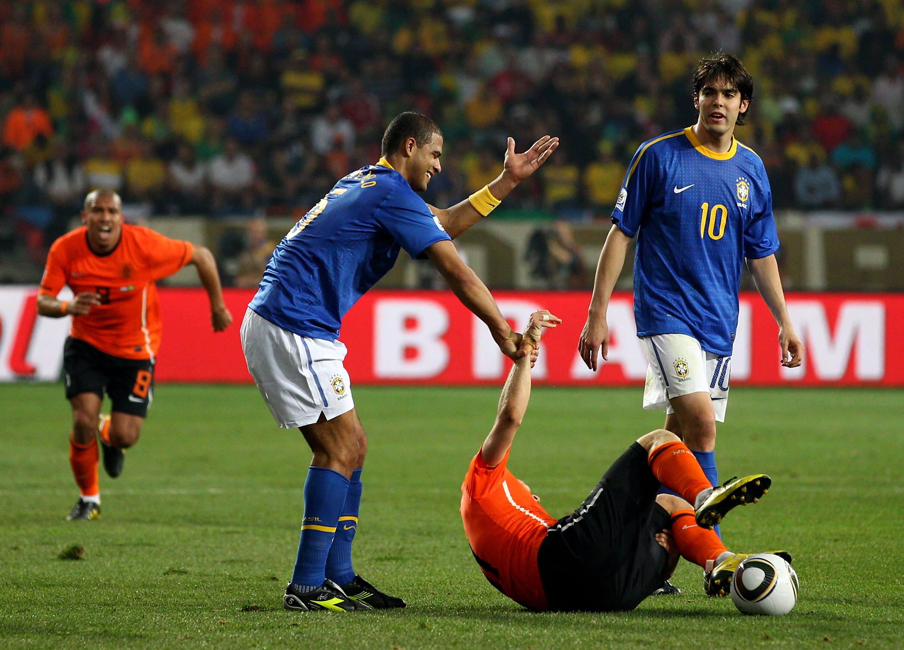 PORT ELIZABETH, SOUTH AFRICA - JULY 02:  Felipe Melo of Brazil attempts to pull up to his feet the injured Arjen Robben of the Netherlands, Melo receives a red card and is sent off for the challenge during the 2010 FIFA World Cup South Africa Quarter Fina