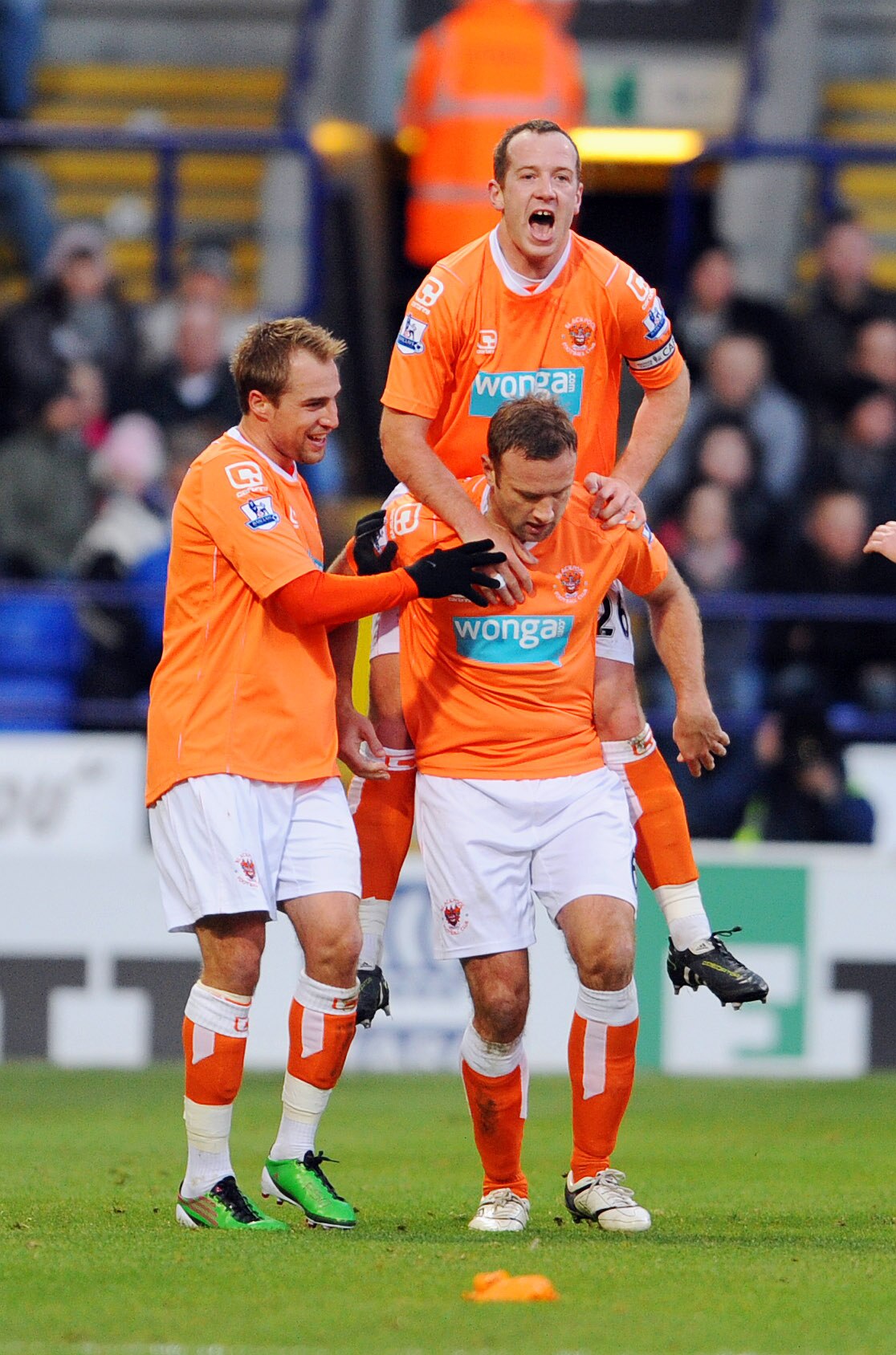 BOLTON, UNITED KINGDOM - NOVEMBER 27: Ian Evatt (ground right) of Blackpool celebrates with team-mate Charlie Adam (Top) after scoring his sides first goal during the Barclays Premier League match between Bolton Wanderers and Blackpool at the Reebok Stadi