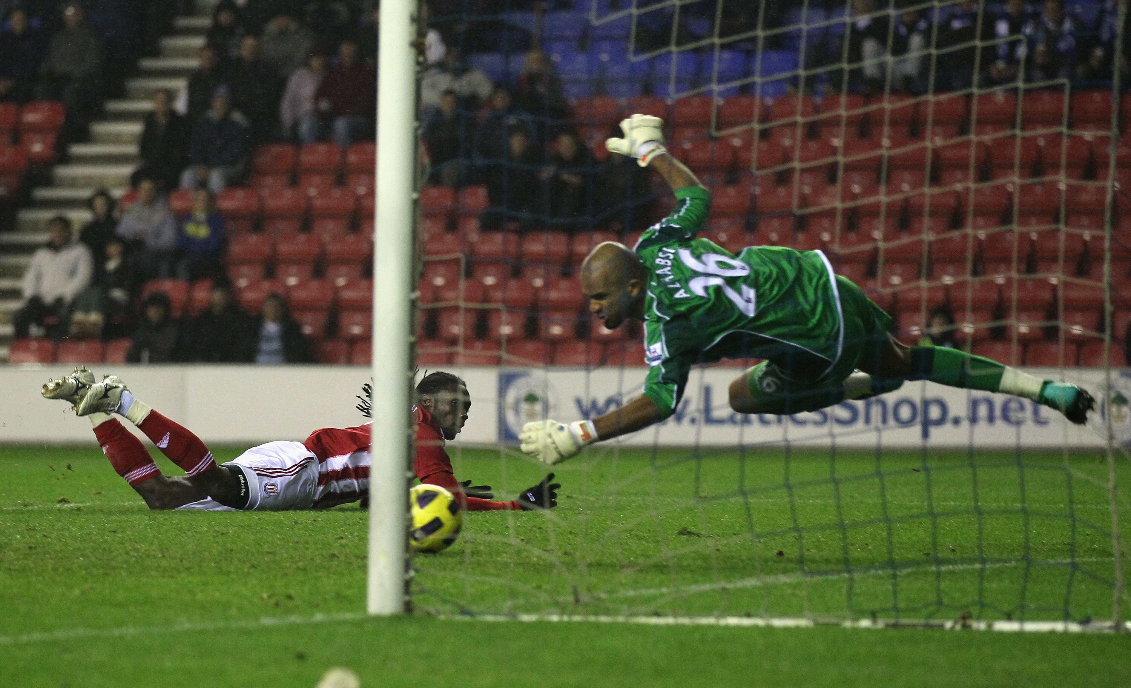 WIGAN, ENGLAND - DECEMBER 04:  Asmir Begovic of Wigan Athletic makes a save from a header by Kenwyne Jones of Stoke City during the Barclays Premier League match between Wigan Athletic and Stoke City at DW Stadium on December 4, 2010 in Wigan, England.  (