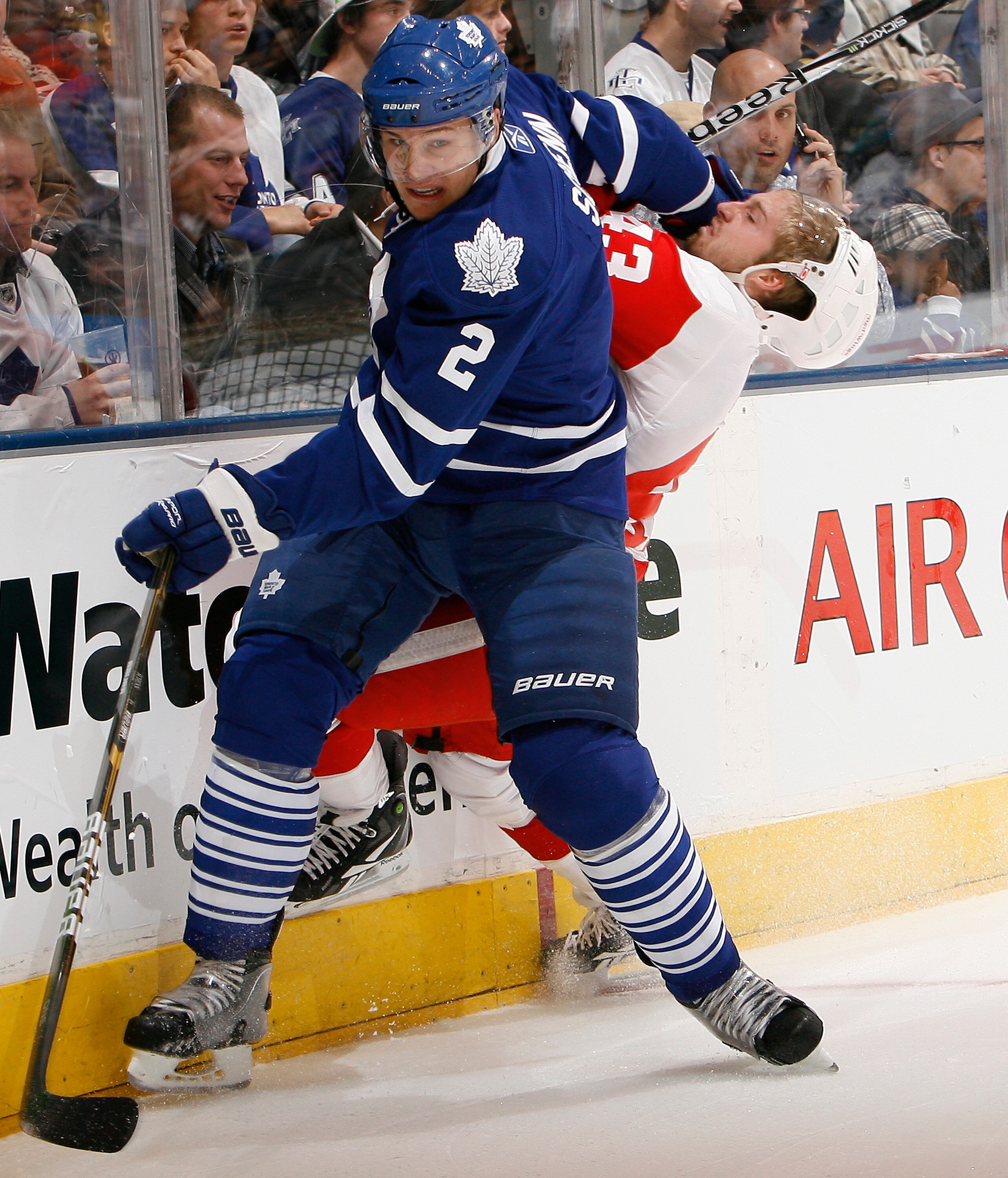 TORONTO - OCTOBER 2: Luke Schenn #2 of the Toronto Maple Leafs hits Darren Helm #43 of the Detroit Red Wings during a preseason NHL game at the Air Canada Centre October 2, 2010 in Toronto, Ontario, Canada. (Photo by Abelimages/Getty Images)