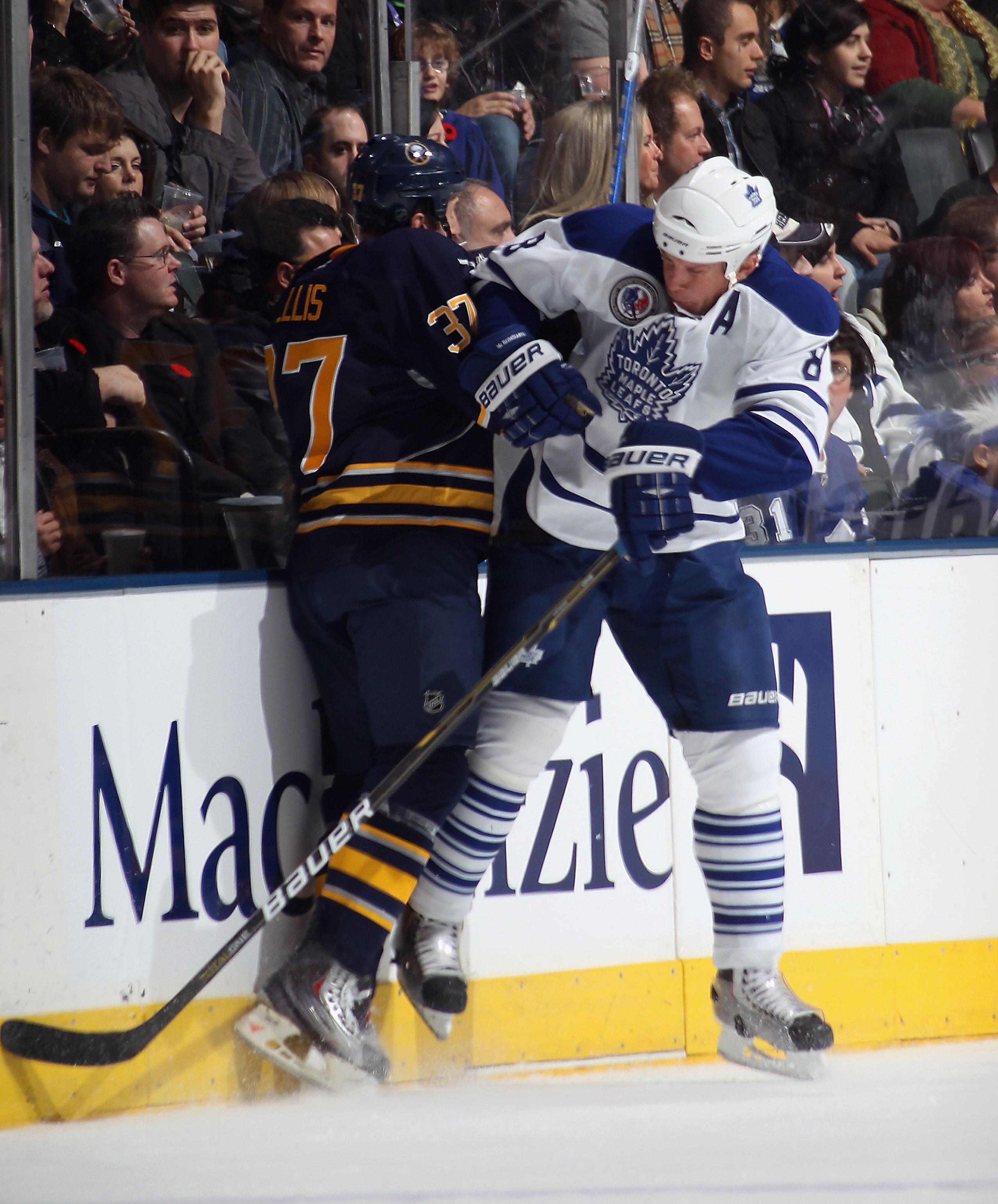TORONTO, ON - NOVEMBER 06:  Mike Komisarek #8 of the Toronto Maple Leafs hits Matt Ellis #37 of the Buffalo Sabres at the Air Canada Centre on November 6, 2010 in Toronto, Canada.  (Photo by Bruce Bennett/Getty Images)