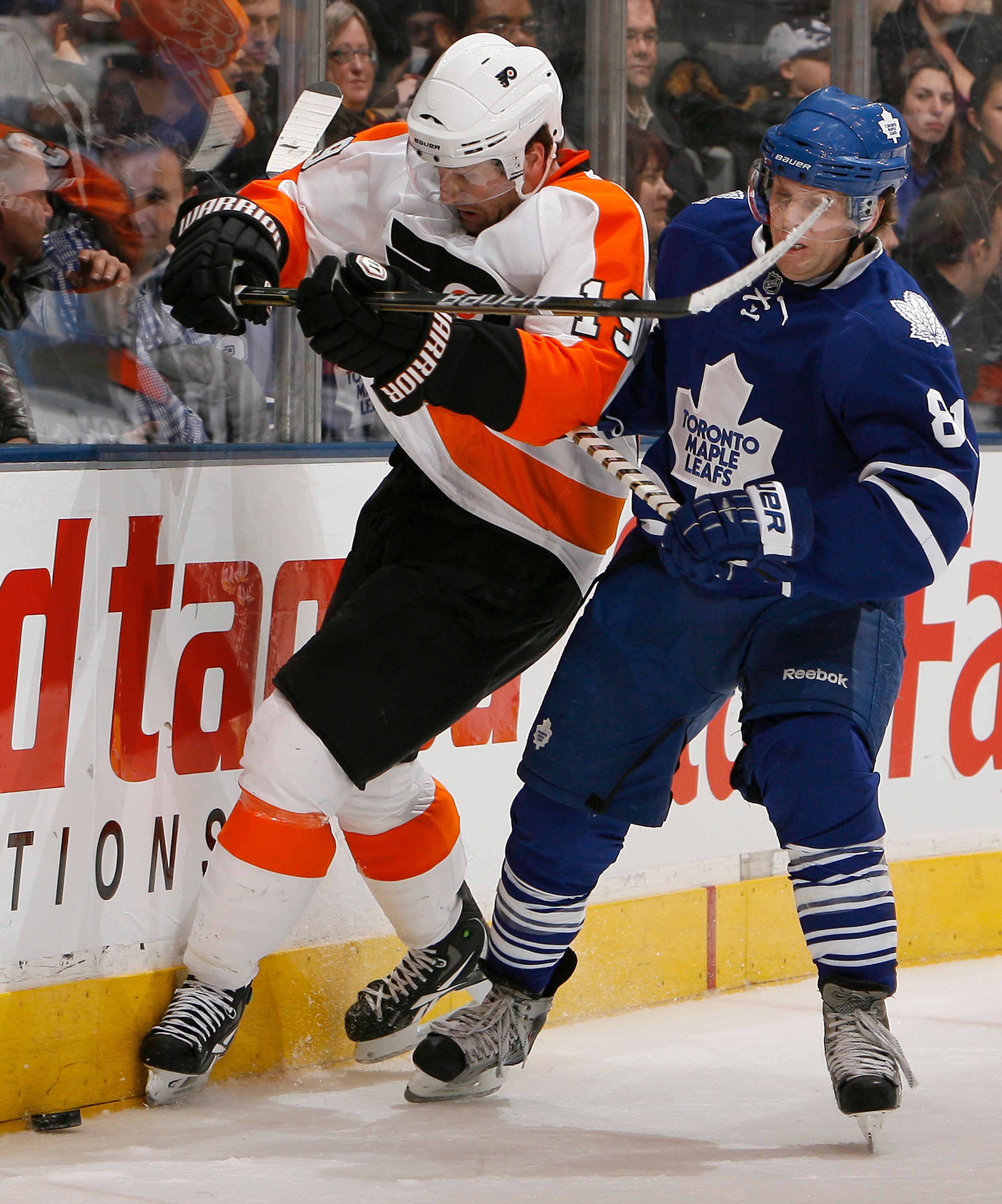 TORONTO, CANADA - DECEMBER 9: Phil Kessel #81 of the Toronto Maple Leafs gets a high-stick by Scott Hartnell #19 of the Philadelphia Flyers during game action at the Air Canada Centre December 9, 2010 in Toronto, Ontario, Canada. (Photo by Abelimages/Gett