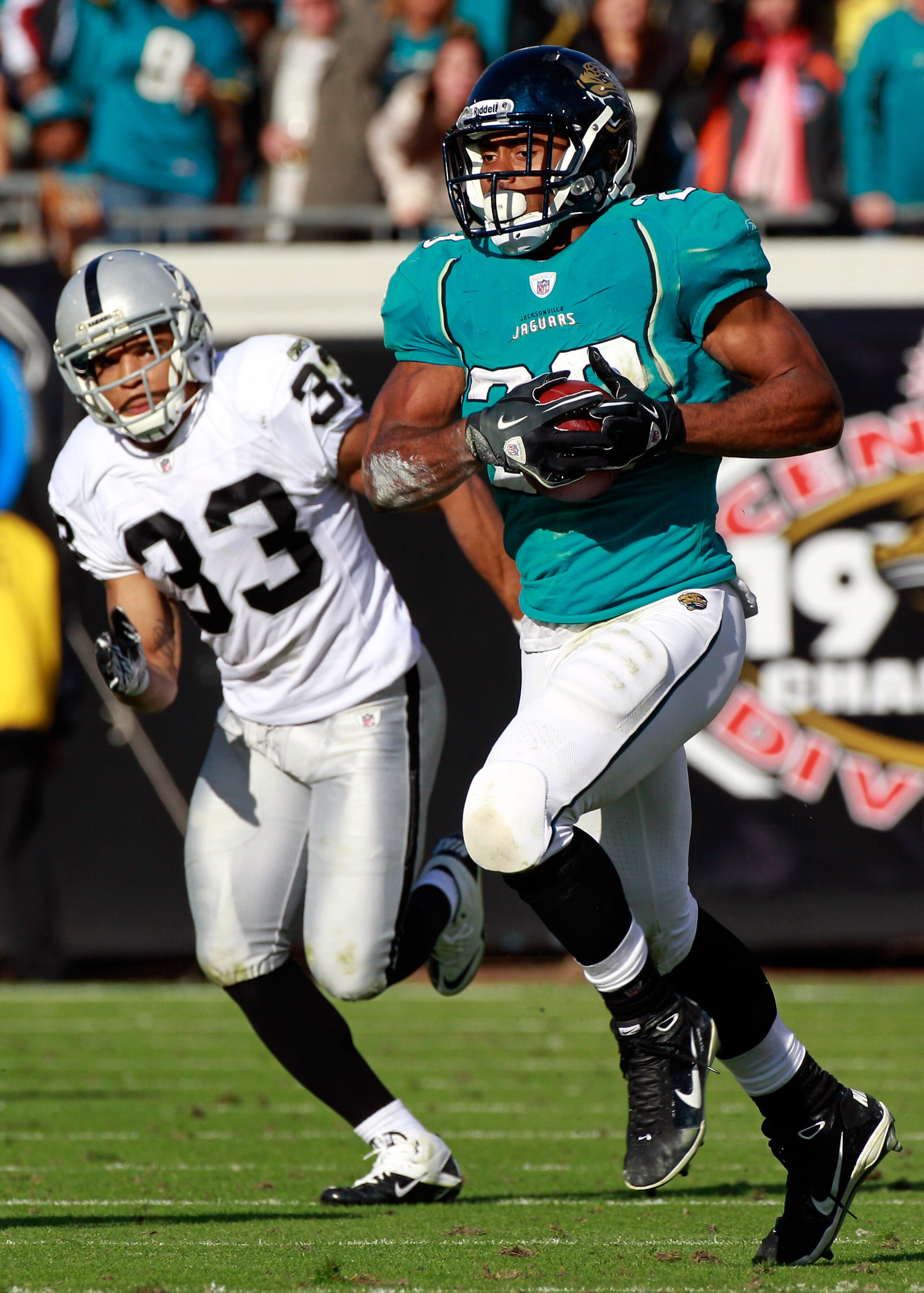 JACKSONVILLE, FL - DECEMBER 12:  Rashad Jenning #23 of the Jacksonville Jaguars runs for yardage while be pursued by Tyvon Branch #33 of the Oakland Raiders during the game at EverBank Field on December 12, 2010 in Jacksonville, Florida.  (Photo by Sam Gr