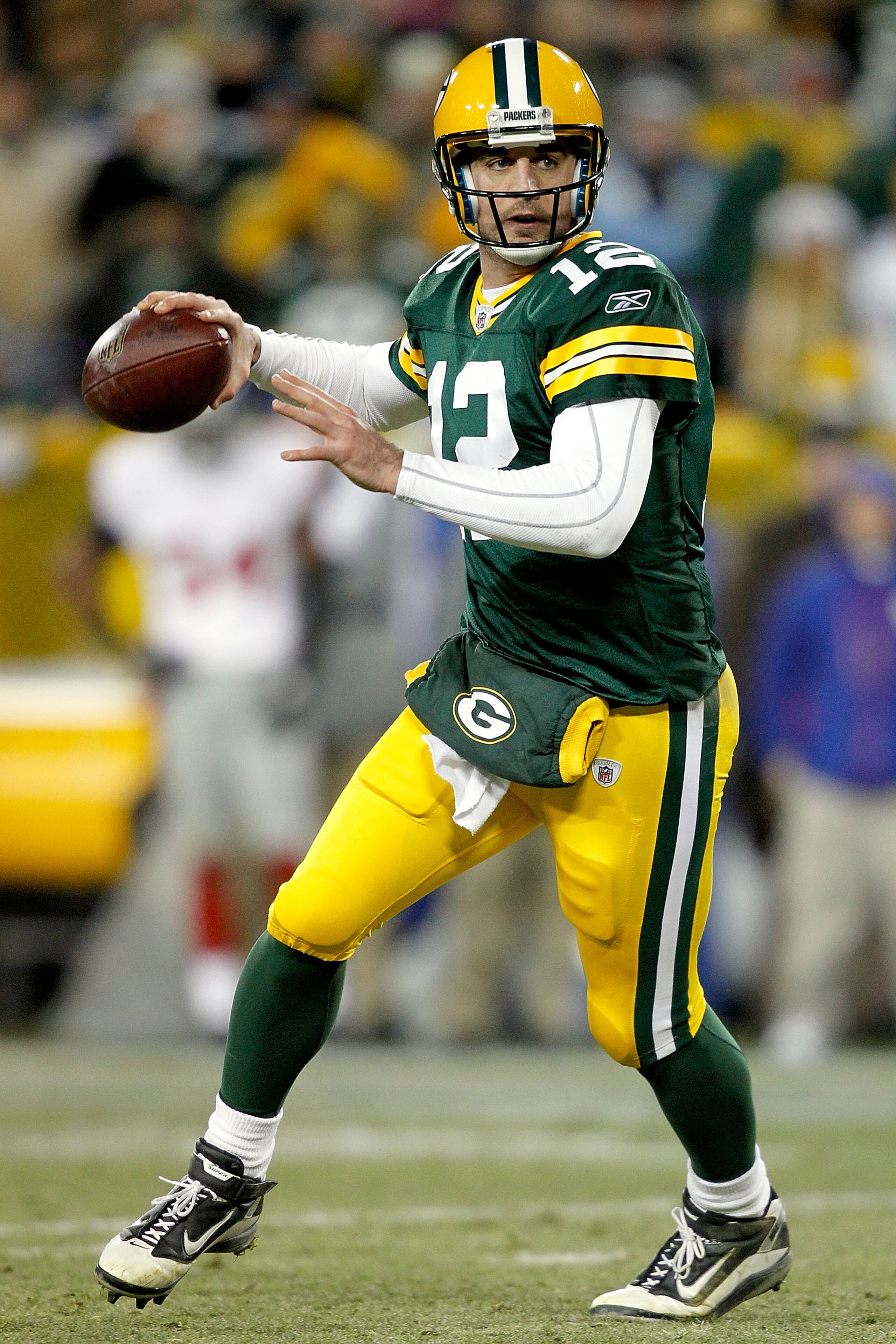 GREEN BAY, WI - DECEMBER 26:  Aaron Rodgers #12 of the Green Bay Packers rolls out of the pocket against the New York Giants at Lambeau Field on December 26, 2010 in Green Bay, Wisconsin.  (Photo by Matthew Stockman/Getty Images)