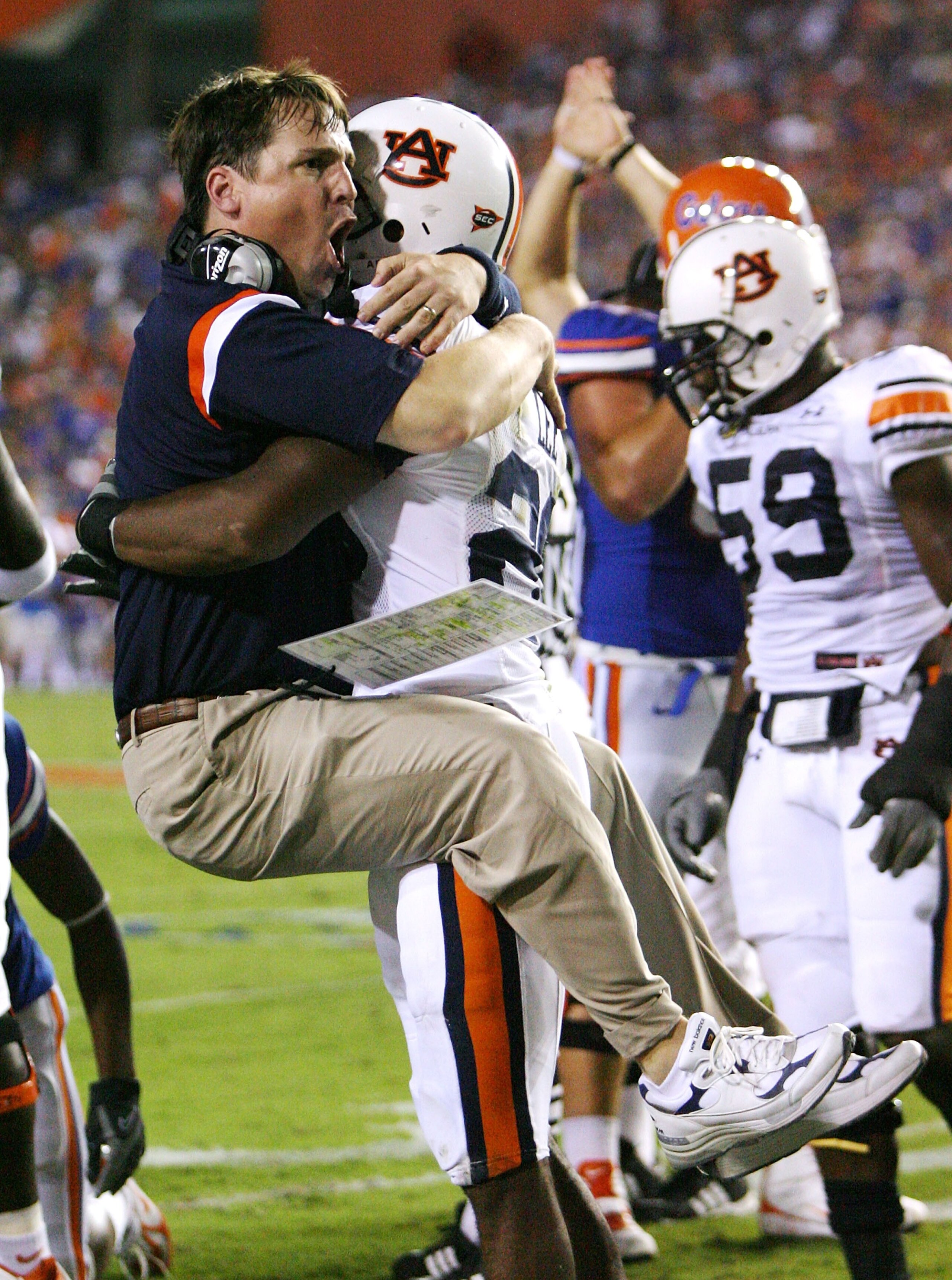 GAINESVILLE, FL - SEPTEMBER 29:  Defensive coordinator Will Muschamp of the Auburn Tigers jumps into the arms of defensive back Patrick Lee #20 after Lee helped cause a fumble late in the first half against the Florida Gators at Ben Hill Griffin Stadium S