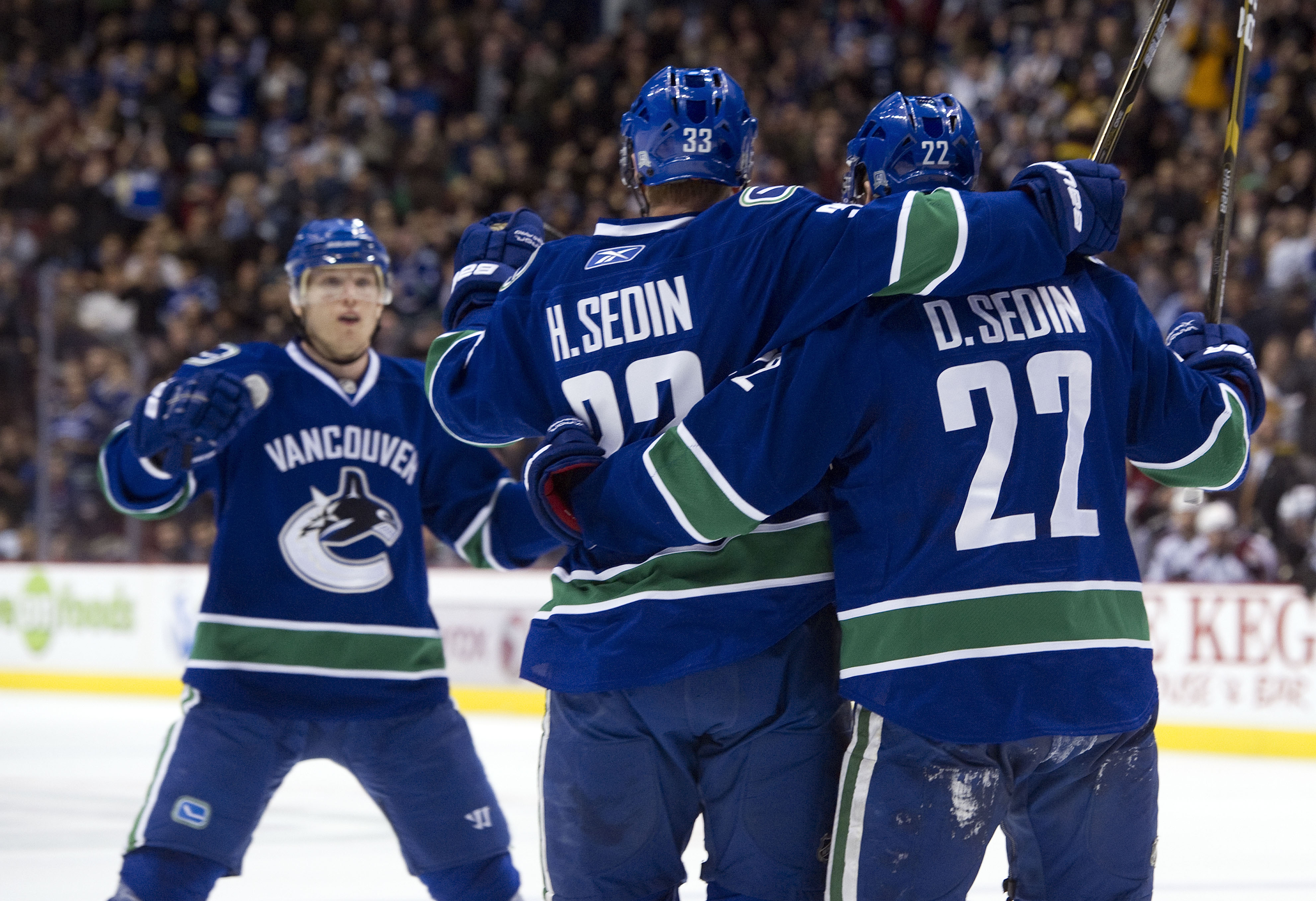 VANCOUVER, CANADA - NOVEMBER 24: Daniel Sedin #22 celebrates with brother Henrik Sedin #33 and Christian Ehrhoff #5 of the Vancouver Canucks after scoring against the Colorado Avalanche during the second period in NHL action on November 24, 2010 at Rogers