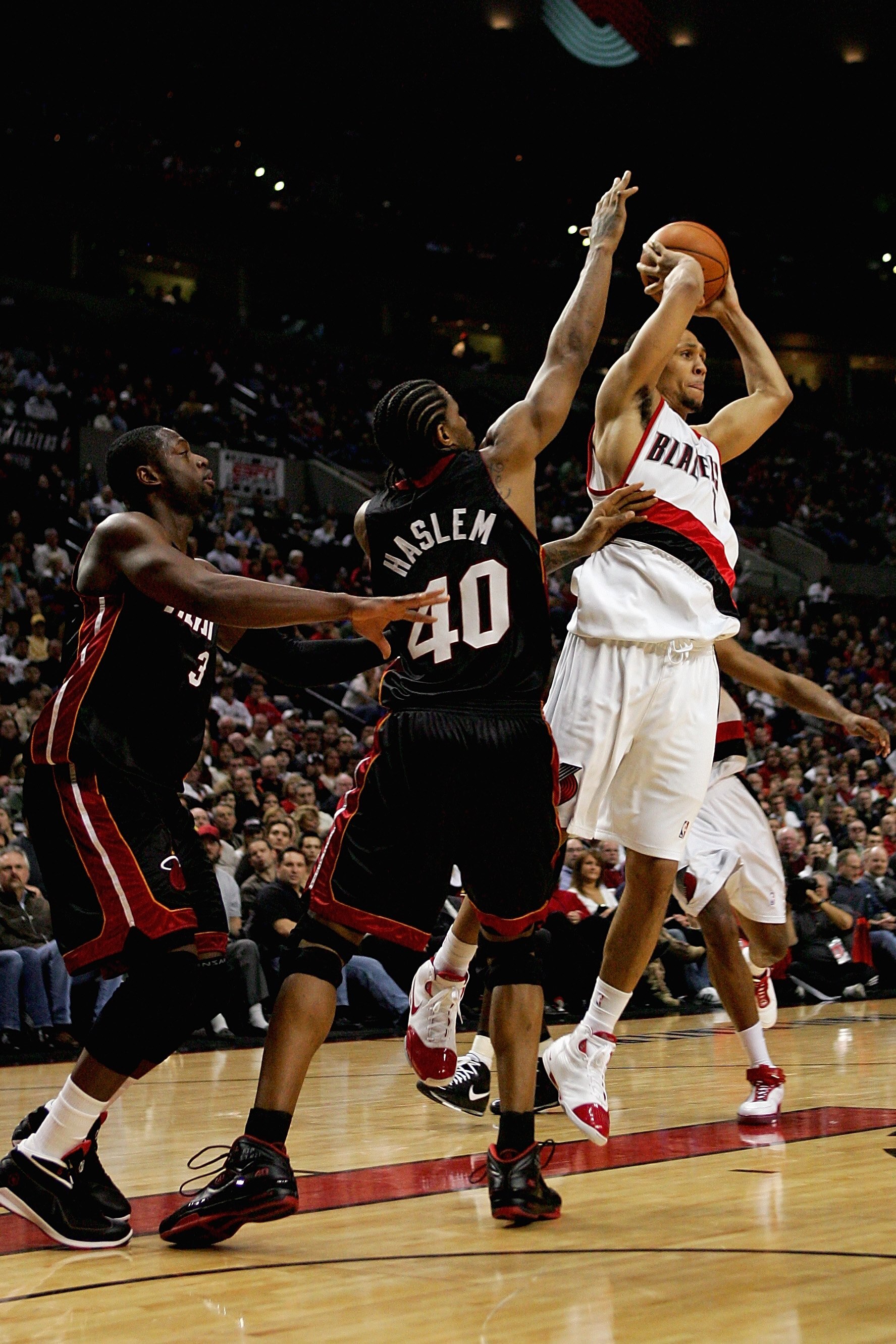 PORTLAND, OR - DECEMBER 6:  Brandon Roy #7 of the Portland Trail Blazers passes the ball away from Udonis Haslem #40 and Dwyane Wade #3 of the Miami Heat  during the game on December 6, 2007 at the Rose Garden in Portland, Oregon.  The Blazers won 112-106