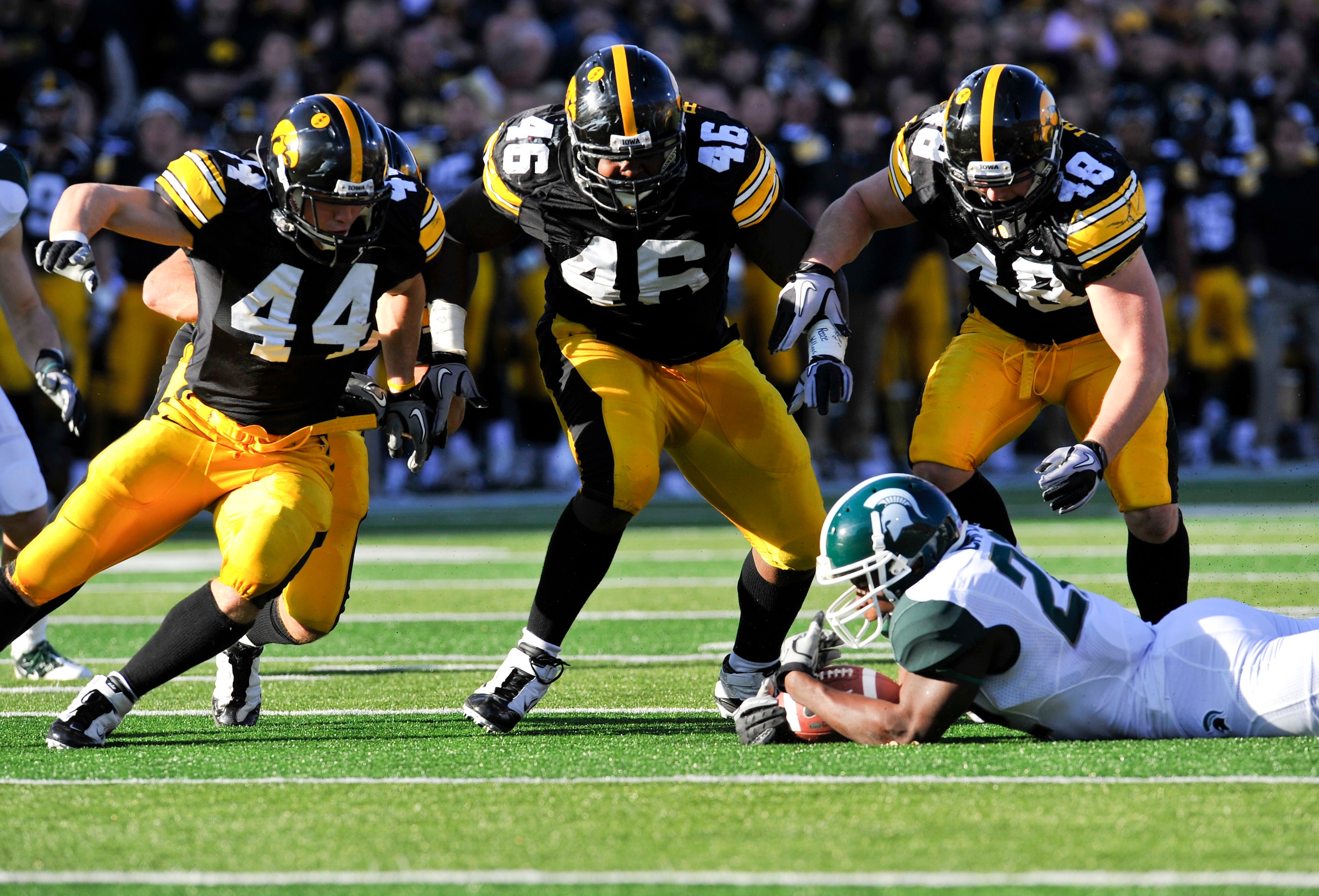 IOWA CITY, IA - OCTOBER 30: Running back Larry Caper #22 of the Michigan State Spartans recovers his fumble as line backer James Morris #44, defensive line man Christian Ballard #46, and line backer Troy Johnson #48 of the University of Iowa Hawkeyes clos