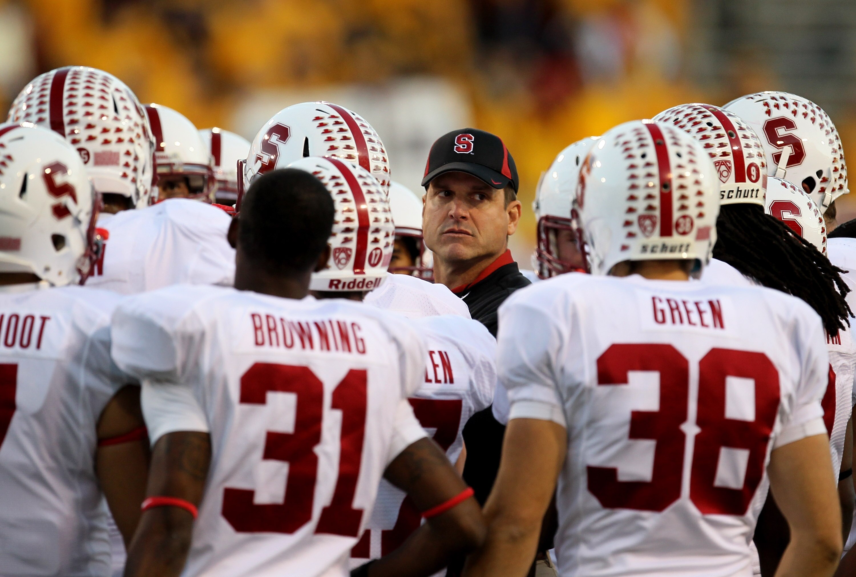 TEMPE, AZ - NOVEMBER 13:  Head coach Jim  Harbaugh of the Stanford Cardinal huddles with his team on as they warm up for the game with the Arizona State Sun Devils  at Sun Devil Stadium on November 13, 2010 in Tempe, Arizona.  (Photo by Stephen Dunn/Getty