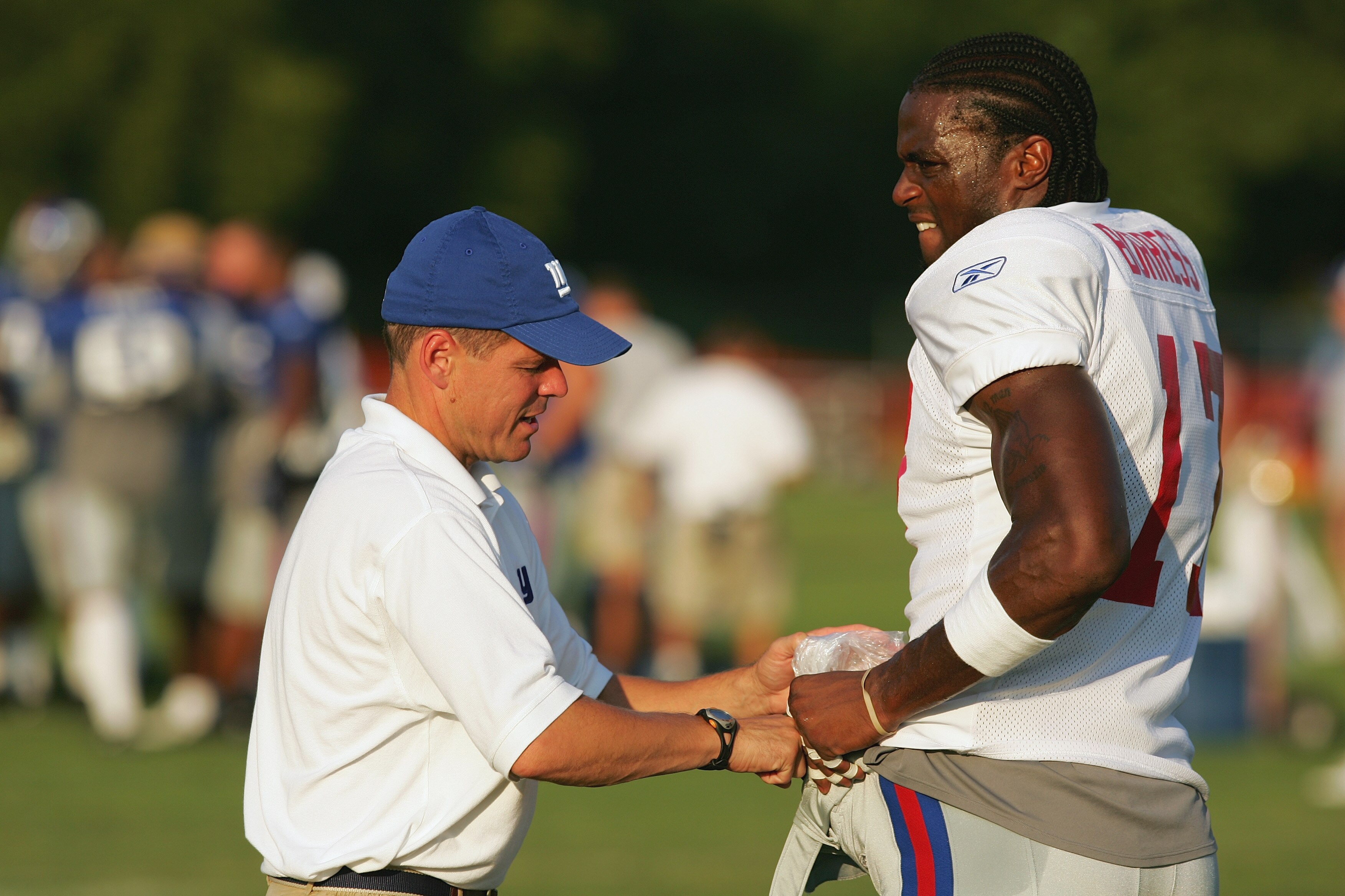 ALBANY, NY - AUGUST 2:  Wide receiver Plaxico Burress #17 of the New York Giants is assisted by a member of the Giants coaching staff during training camp on August 2, 2005 in Albany, New York. (Photo by Ezra Shaw/Getty Images)