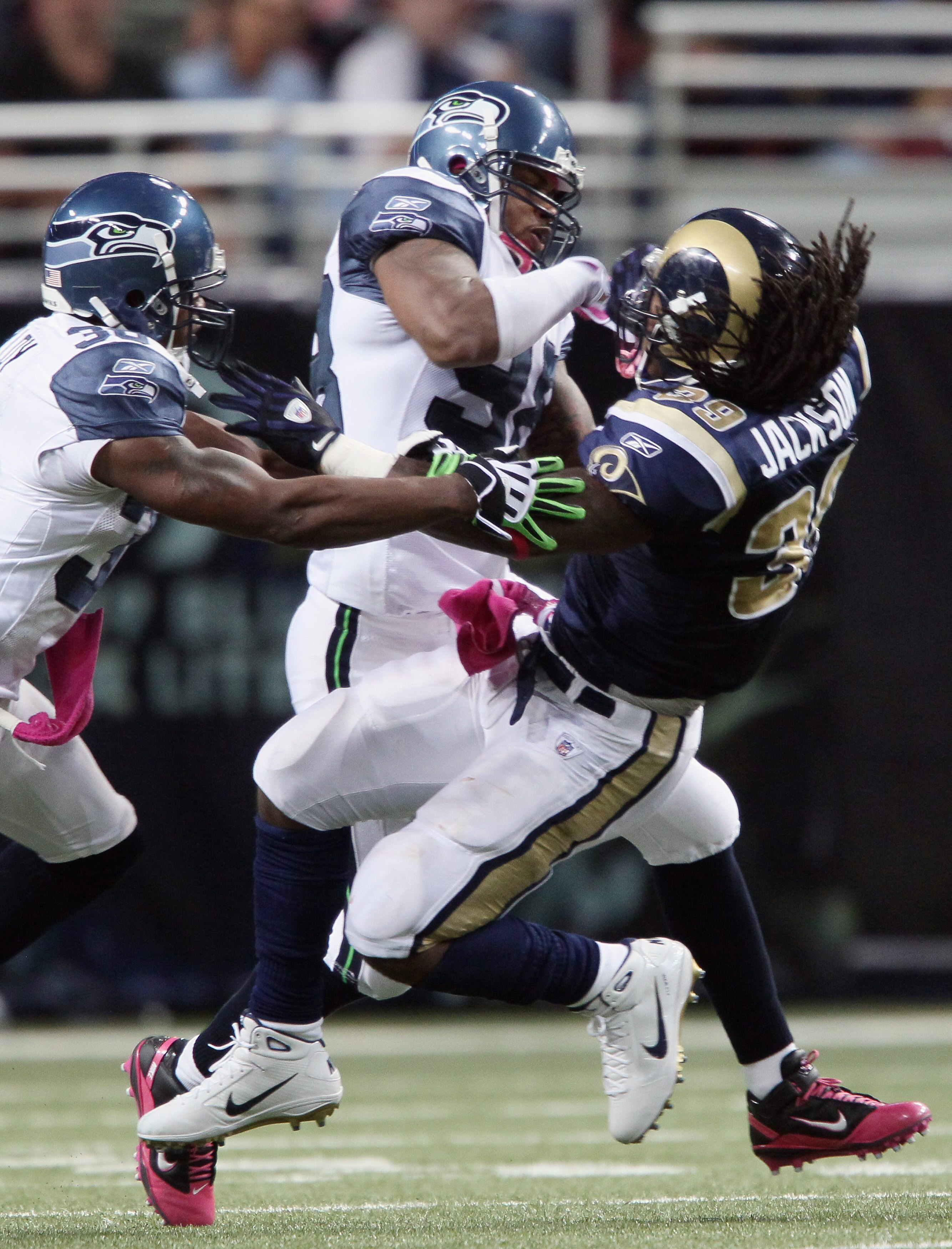 ST. LOUIS - OCTOBER 03:  Raheem Brock #98 and Lawyer Milloy #36 of the Seattle Seahawks take down Steven Jackson #39 of the St. Louis Rams on October 3, 2010 at Edward Jones Dome in St. Louis, Missouri.  (Photo by Elsa/Getty Images)