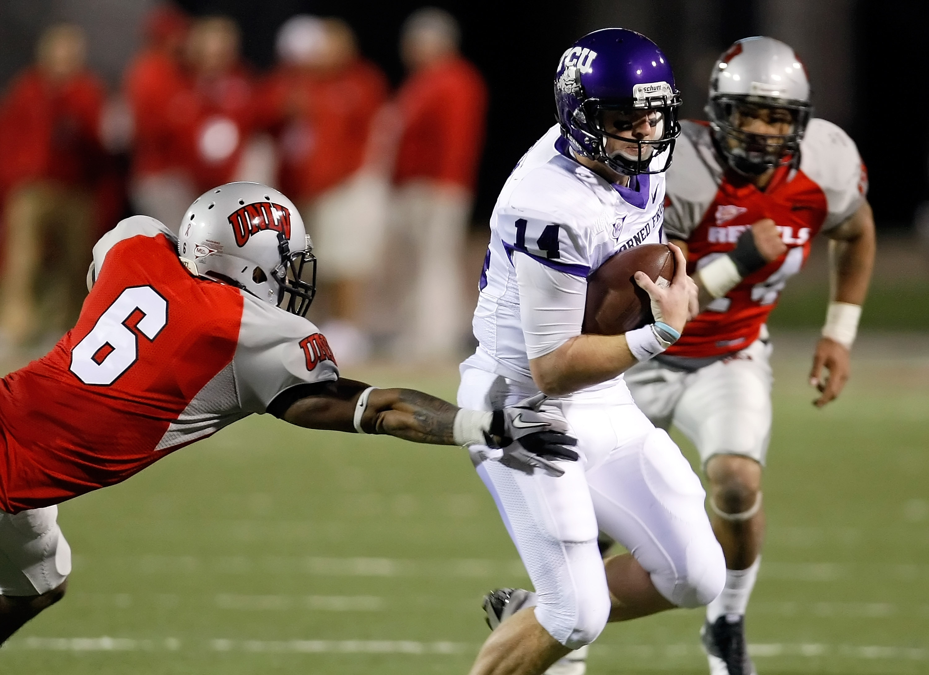 LAS VEGAS - OCTOBER 30:  Quarterback Andy Dalton #14 of the Texas Christian University Horned Frogs runs for yardage against Mike Clausen #6 UNLV Rebels at Sam Boyd Stadium October 30, 2010 in Las Vegas, Nevada. TCU won 48-6.  (Photo by Ethan Miller/Getty