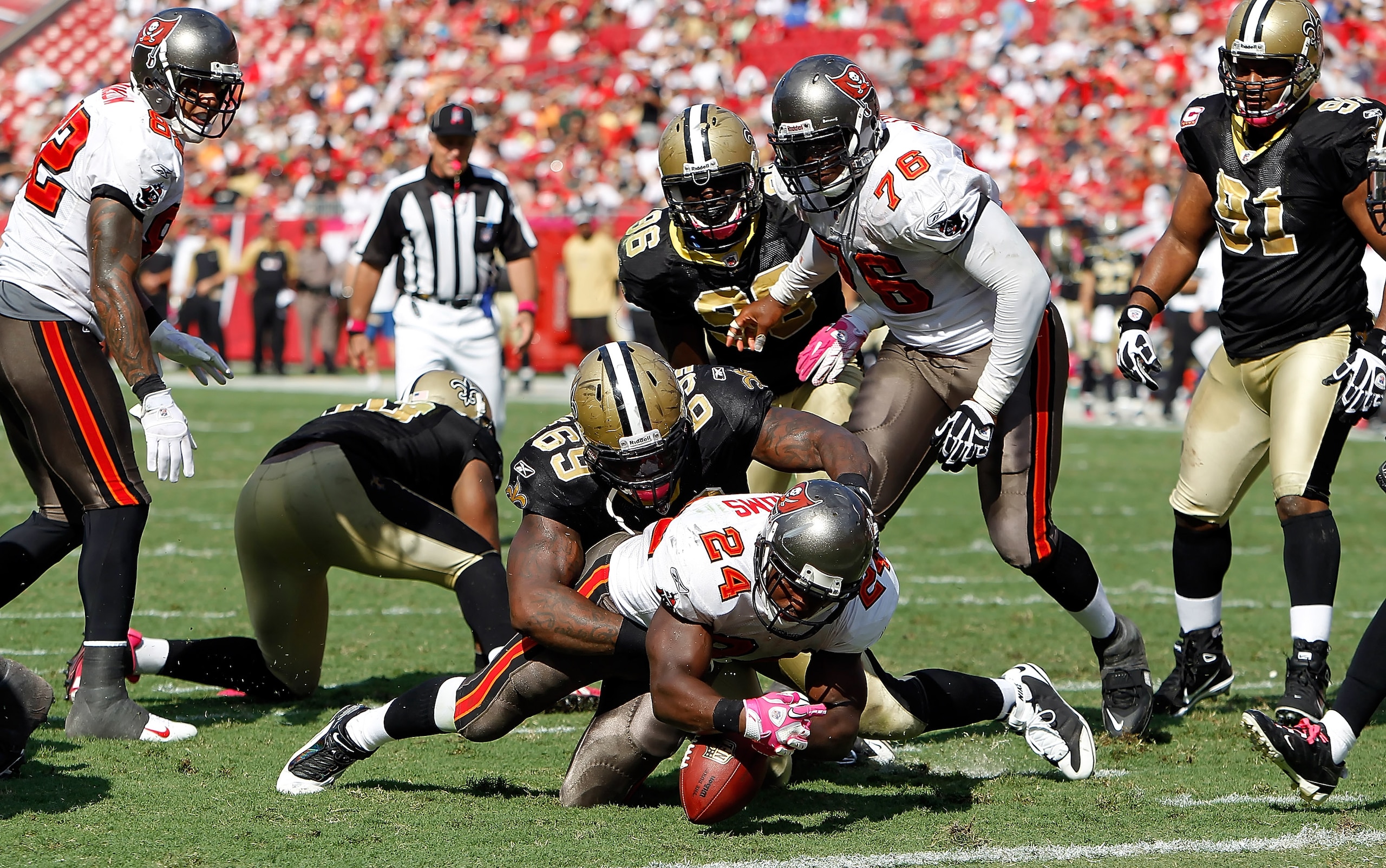 TAMPA, FL - OCTOBER 17:  Running back Carnell Williams #24 of the Tampa Bay Buccaneers is stopped just short of the goal line by defensive lineman Anthony Hargrove #69 of the New Orleans Saints during the game at Raymond James Stadium on October 17, 2010