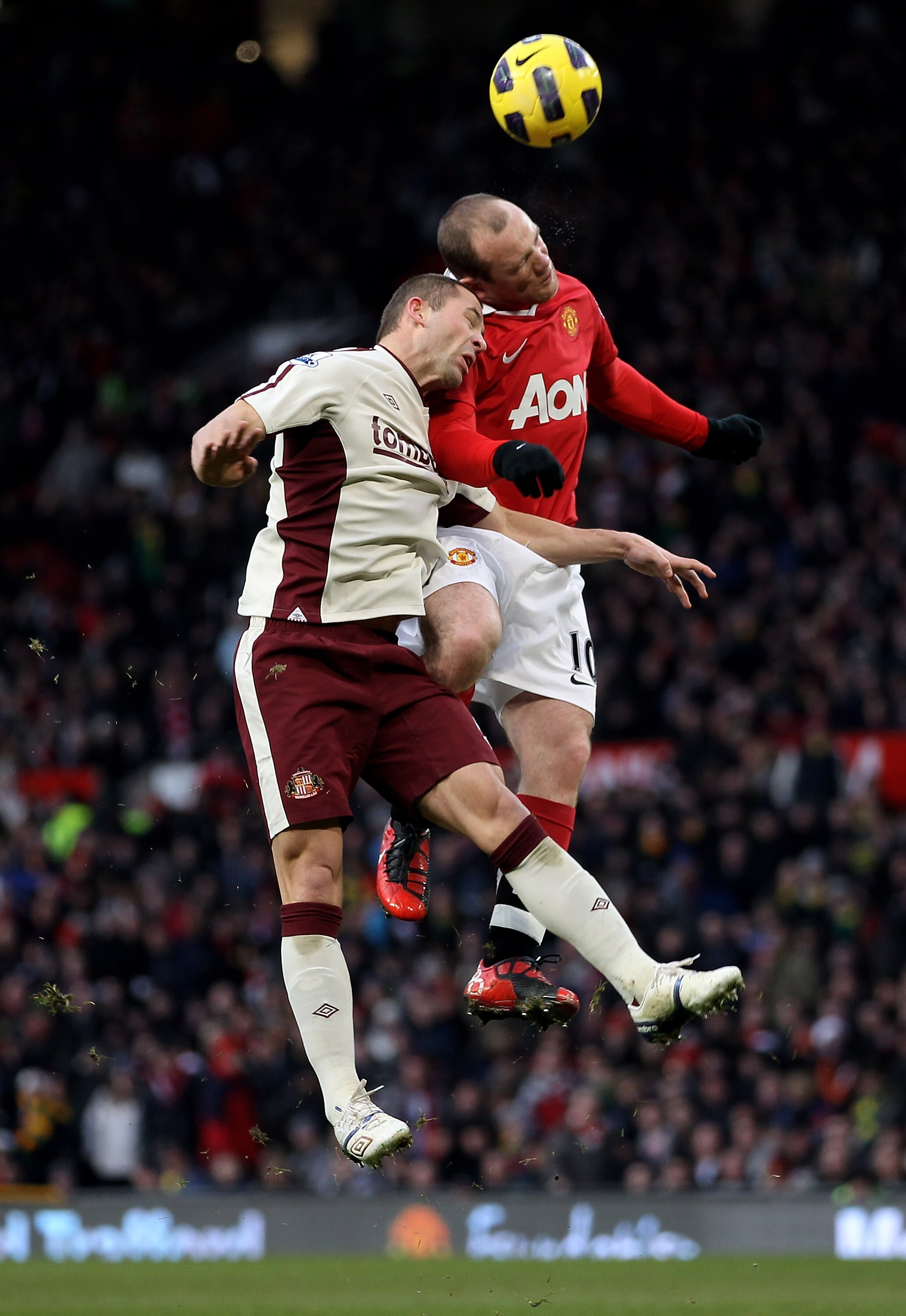 MANCHESTER, ENGLAND - DECEMBER 26:  Wayne Rooney of Manchester United goes up for a header with Phil Bardsley of Sunderland during the Barclays Premier League match between Manchester United and Sunderland at Old Trafford on December 26, 2010 in Mancheste
