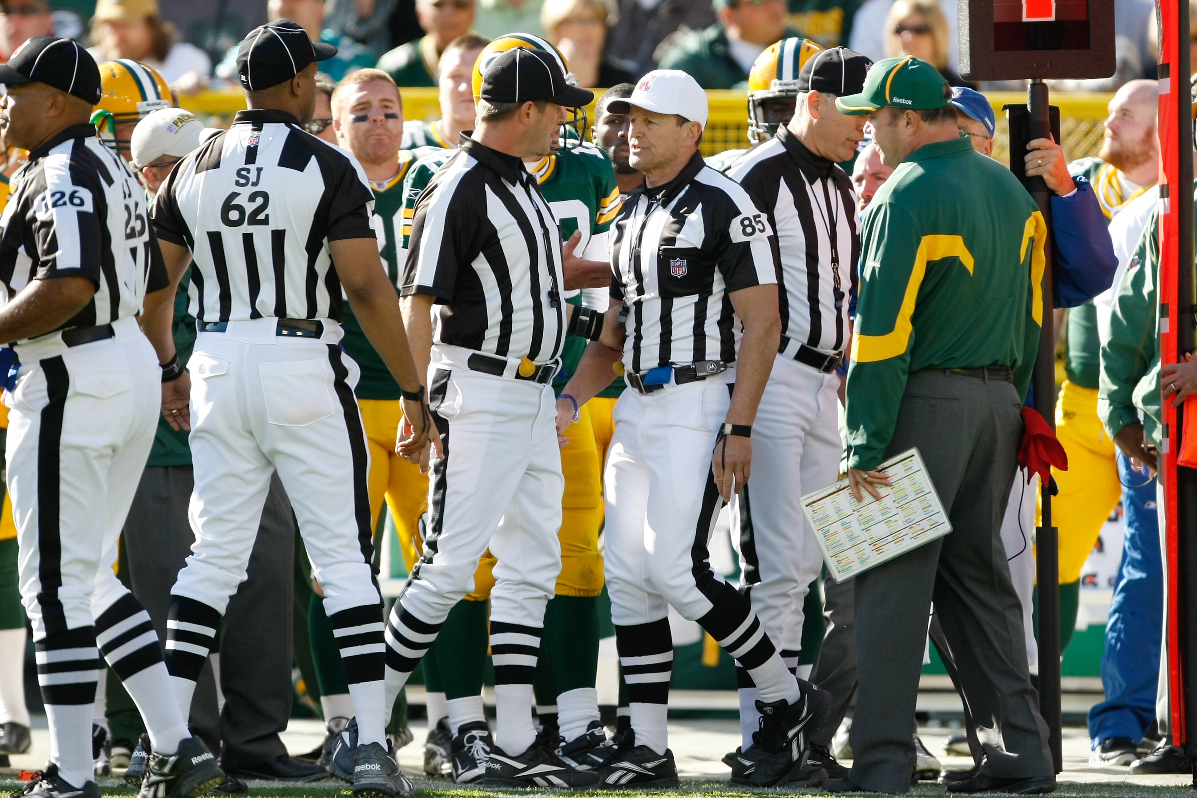 GREEN BAY, WI - OCTOBER 17: Mike McCarthy of the Green Bay Packers argues with Ed Hochuli #85 as he follows him and other officials on the field after a controversial call in the 4th quarter against the Miami Dolphins at Lambeau Field on October 17, 2010