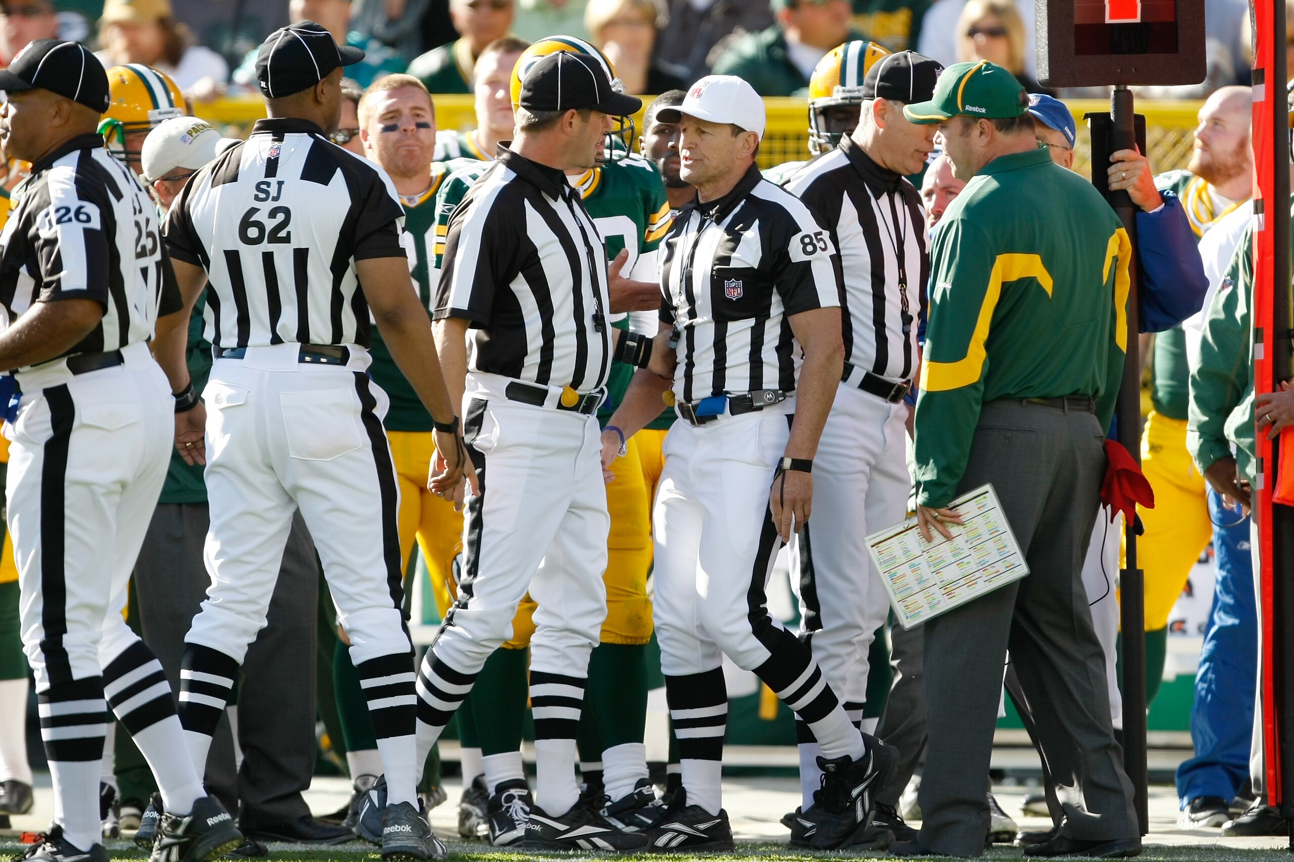 GREEN BAY, WI - OCTOBER 17: Mike McCarthy of the Green Bay Packers argues with Ed Hochuli #85 as he follows him and other officials on the field after a controversial call in the 4th quarter against the Miami Dolphins at Lambeau Field on October 17, 2010