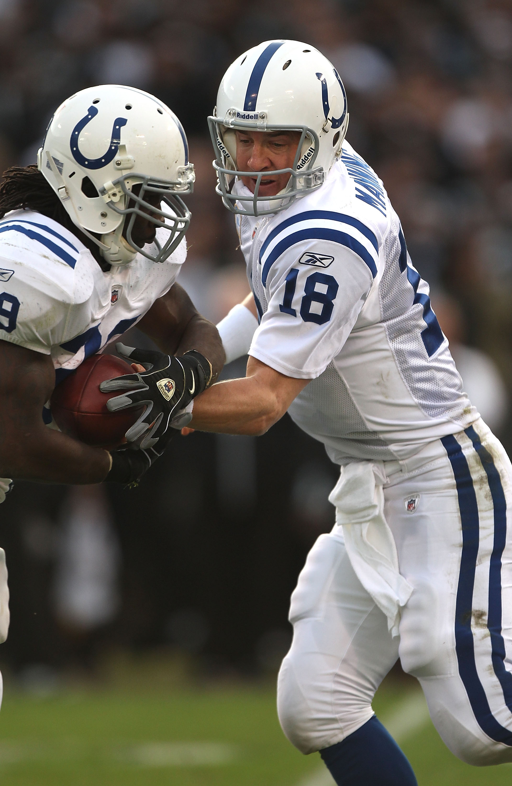 OAKLAND, CA - DECEMBER 26:  Peyton Manning #18 of the Indianapolis Colts hands off to Joseph Addai #29 against the Oakland Raiders during an NFL game at Oakland-Alameda County Coliseum on December  26, 2010 in Oakland, California.  (Photo by Jed Jacobsohn