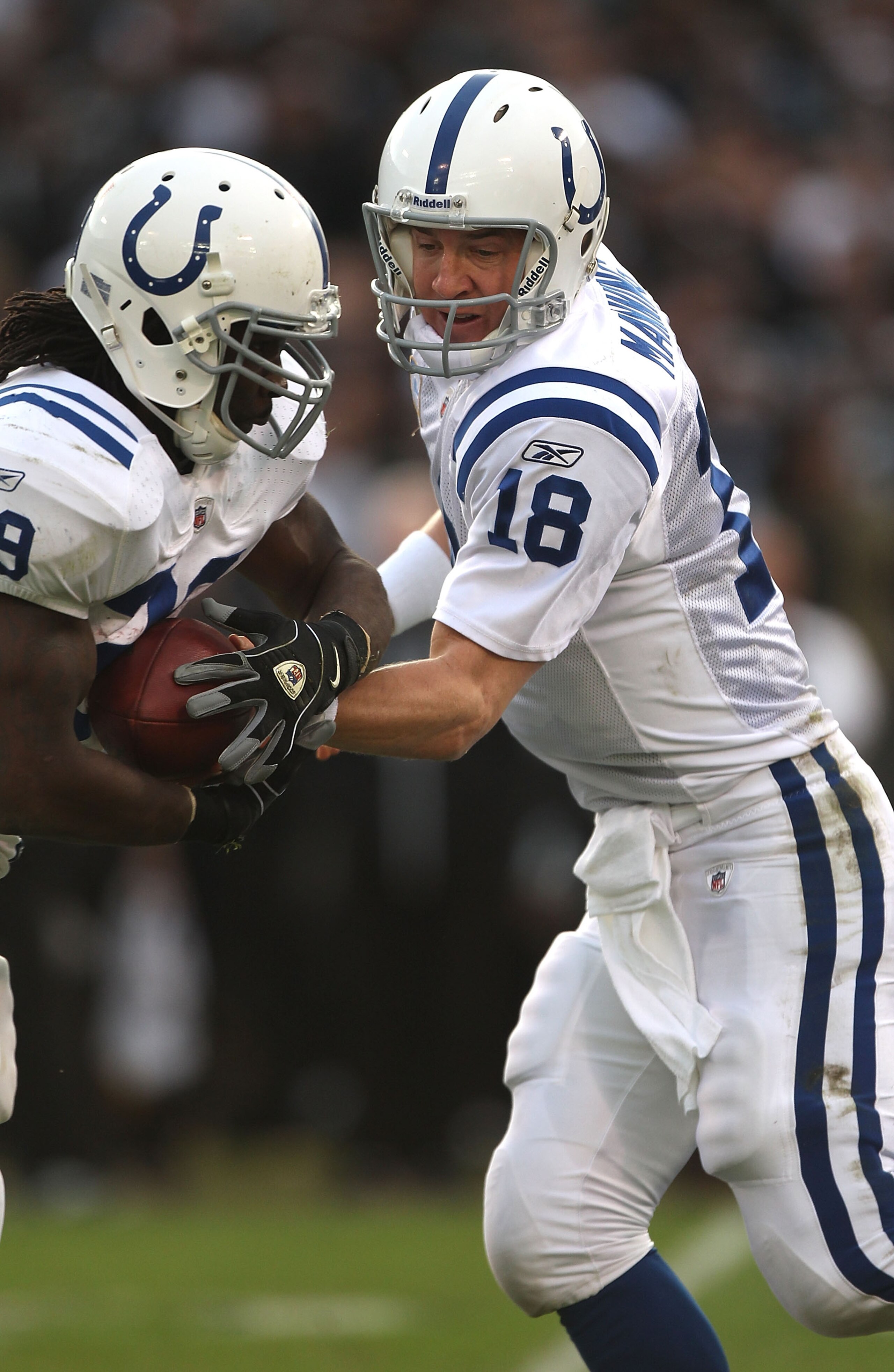 OAKLAND, CA - DECEMBER 26:  Peyton Manning #18 of the Indianapolis Colts hands off to Joseph Addai #29 against the Oakland Raiders during an NFL game at Oakland-Alameda County Coliseum on December  26, 2010 in Oakland, California.  (Photo by Jed Jacobsohn