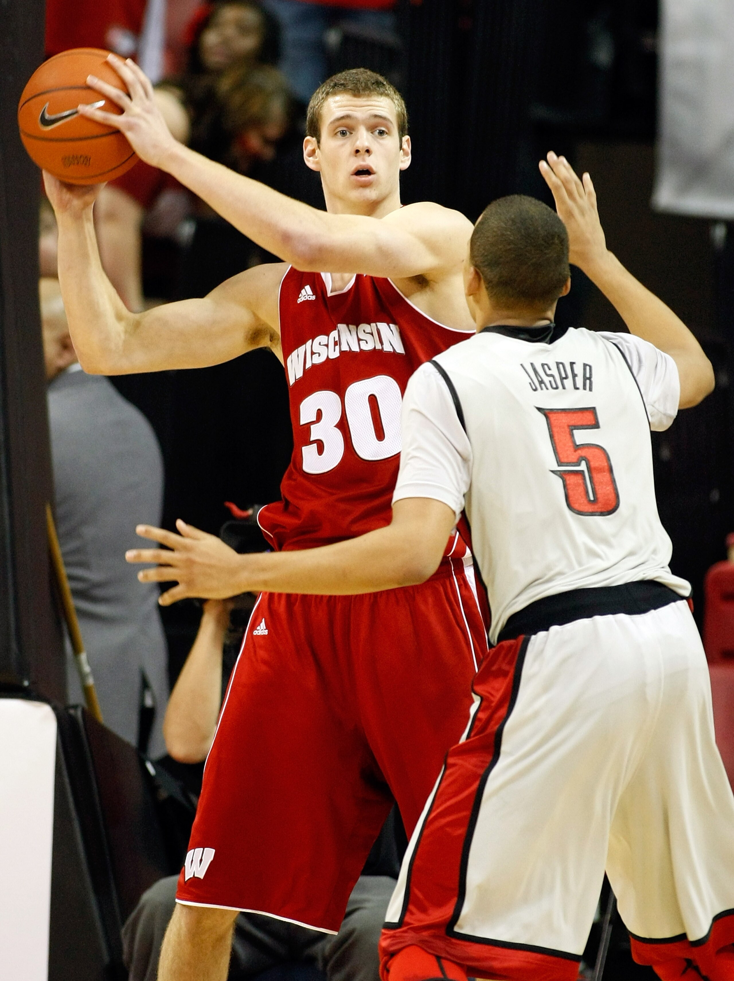 LAS VEGAS - NOVEMBER 20:  Jon Leuer #30 of the Wisconsin Badgers looks to pass the ball inbounds as Derrick Jasper #5 of the UNLV Rebels defends during their game at the Thomas & Mack Center November 20, 2010 in Las Vegas, Nevada. UNLV won 68-65.  (Photo