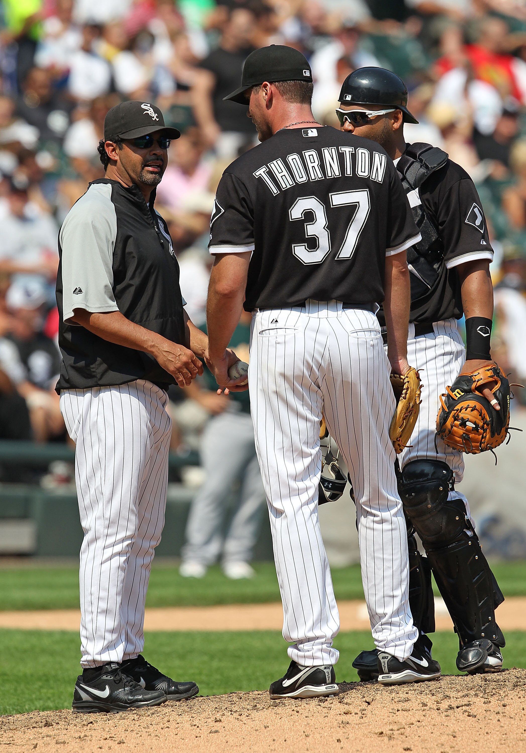 CHICAGO - AUGUST 01: Manager Ozzie Guillen #13 of the Chicago White Sox talks with Matt Thorton #37 and Ramon Castro #27 in the 8th inning against the Oakland Athletics at U.S. Cellular Field on August 1, 2010 in Chicago, Illinois. The White Sox defeated