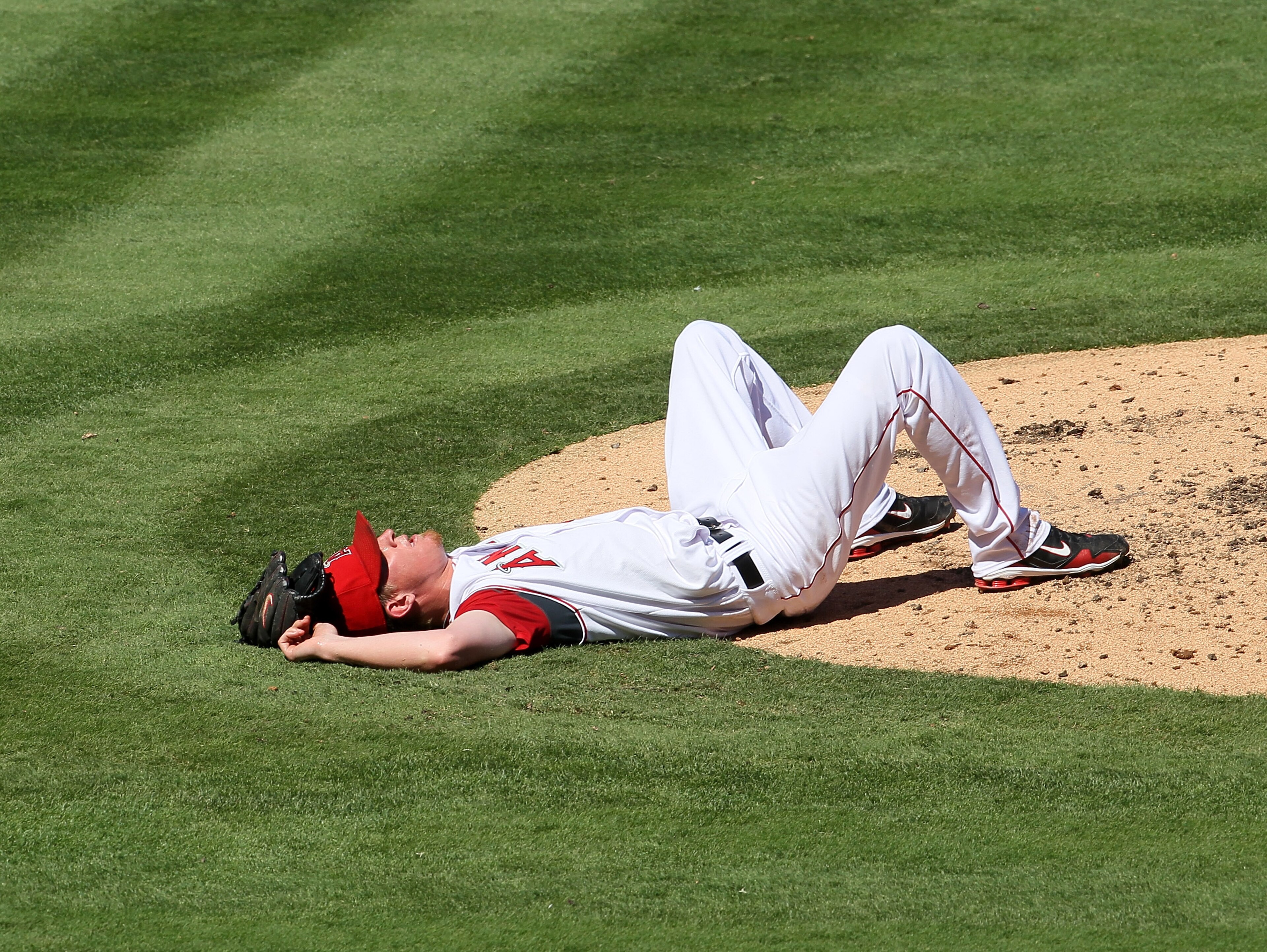 ANAHEIM, CA - SEPTEMBER 26:  Pitcher Jered Weaver #36 of the Los Angeles Angels of Anaheim lies on the ground after grabbing a line drive that would have hit him in the head off the bat of Juan Pierre of the Chicago White Sox in the third inning on Septem