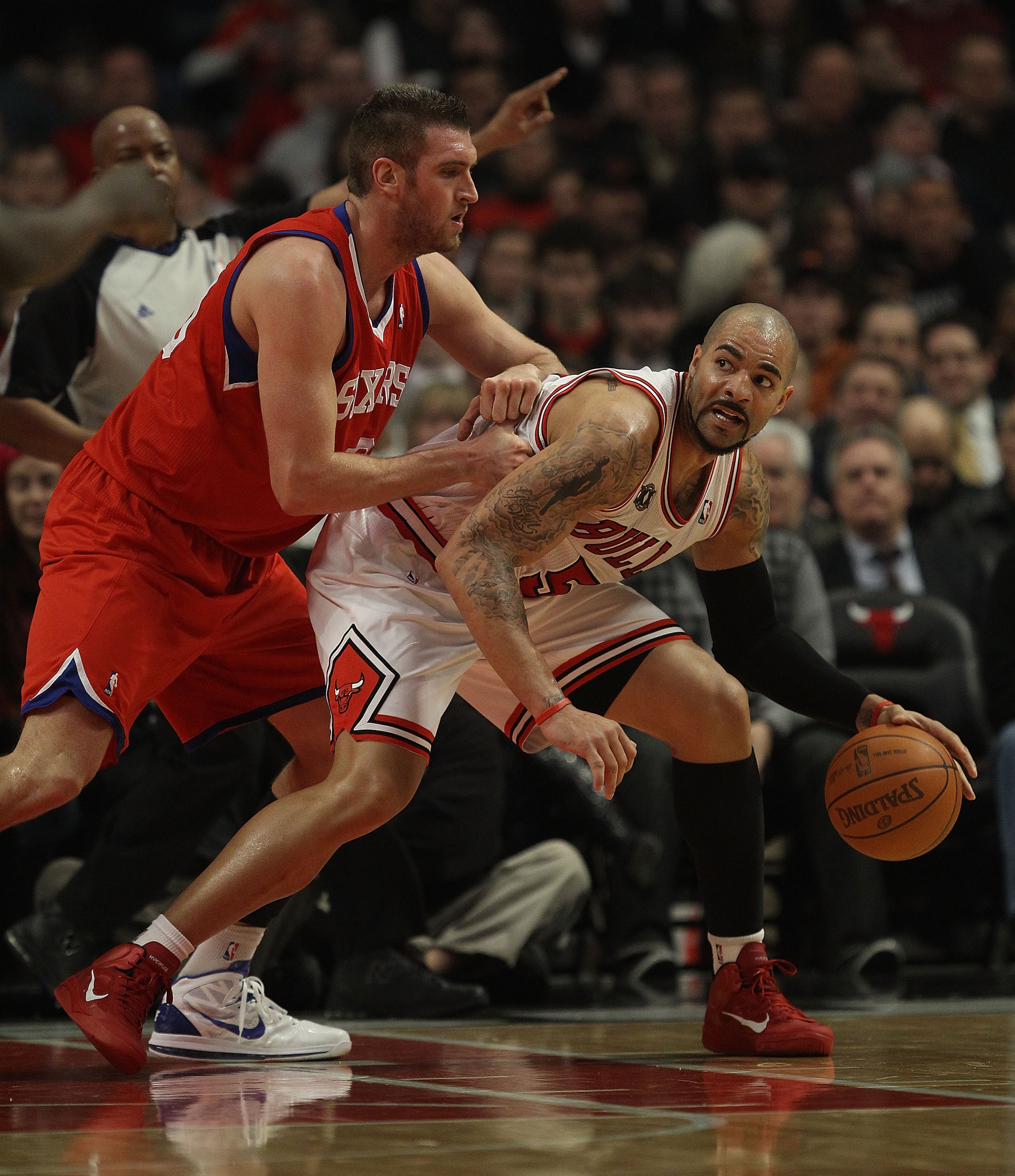 CHICAGO, IL - DECEMBER 21: Carlos Boozer #5 of the Chicago Bulls moves against Spencer Hawes #00 of the Philadelphia 76ers at the United Center on December 21, 2010 in Chicago, Illinois. The Bulls defeated the 76ers 121-76. NOTE TO USER: User expressly ac CHICAGO, IL - DECEMBER 21: Carlos Boozer #5 of the Chicago Bulls moves against Spencer Hawes #00 of the Philadelphia 76ers at the United Center on December 21, 2010 in Chicago, Illinois. The Bulls defeated the 76ers 121-76. NOTE TO USER: User expressly ac
