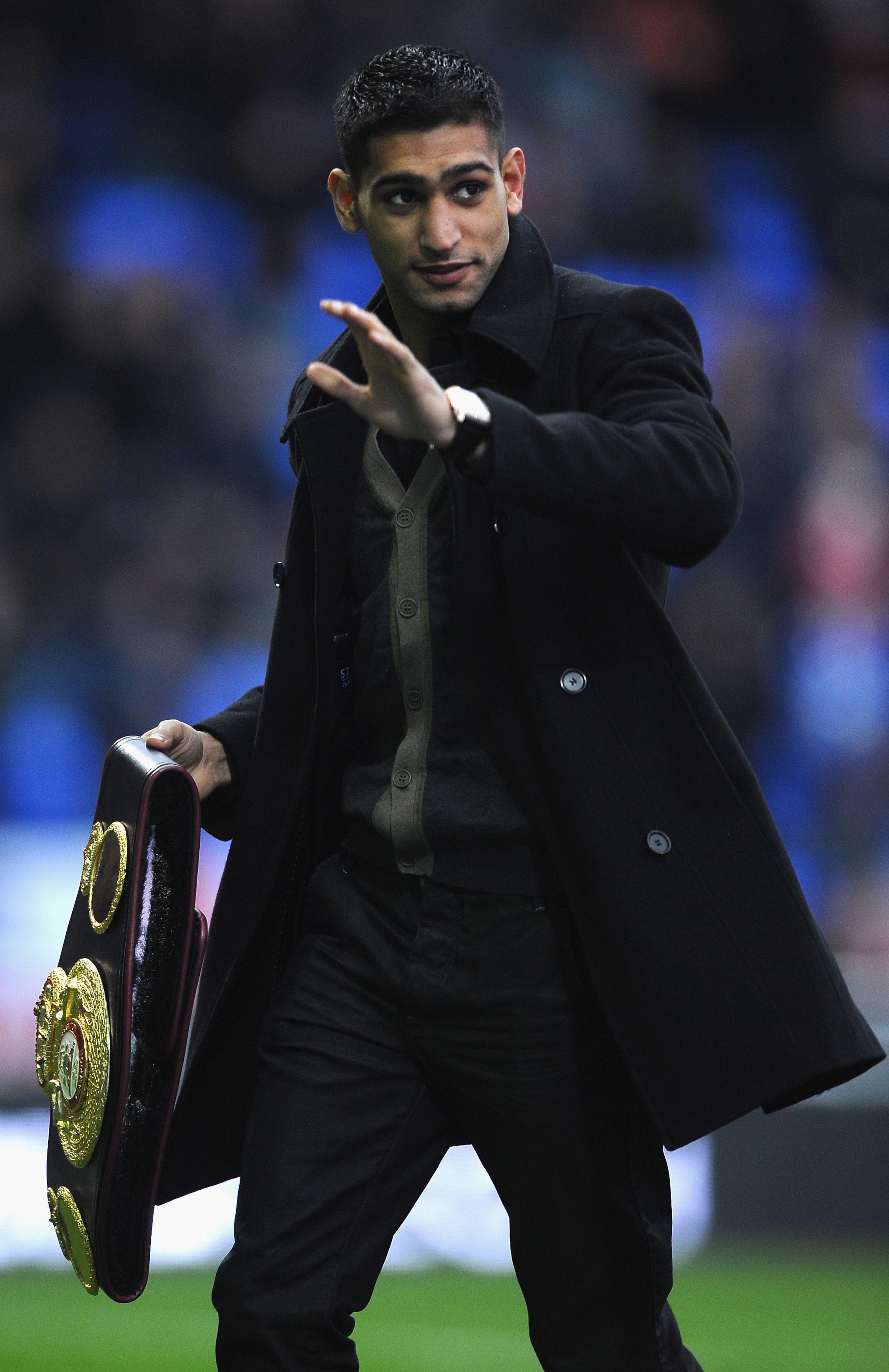 BOLTON, ENGLAND - DECEMBER 26:  Boxer Amir Khan shows his latest belt to the crowd during the Barclays Premier League match between Bolton Wanderers and West Bromwich Albion at Reebok Stadium on December 26, 2010 in Bolton, England.  (Photo by Laurence Gr