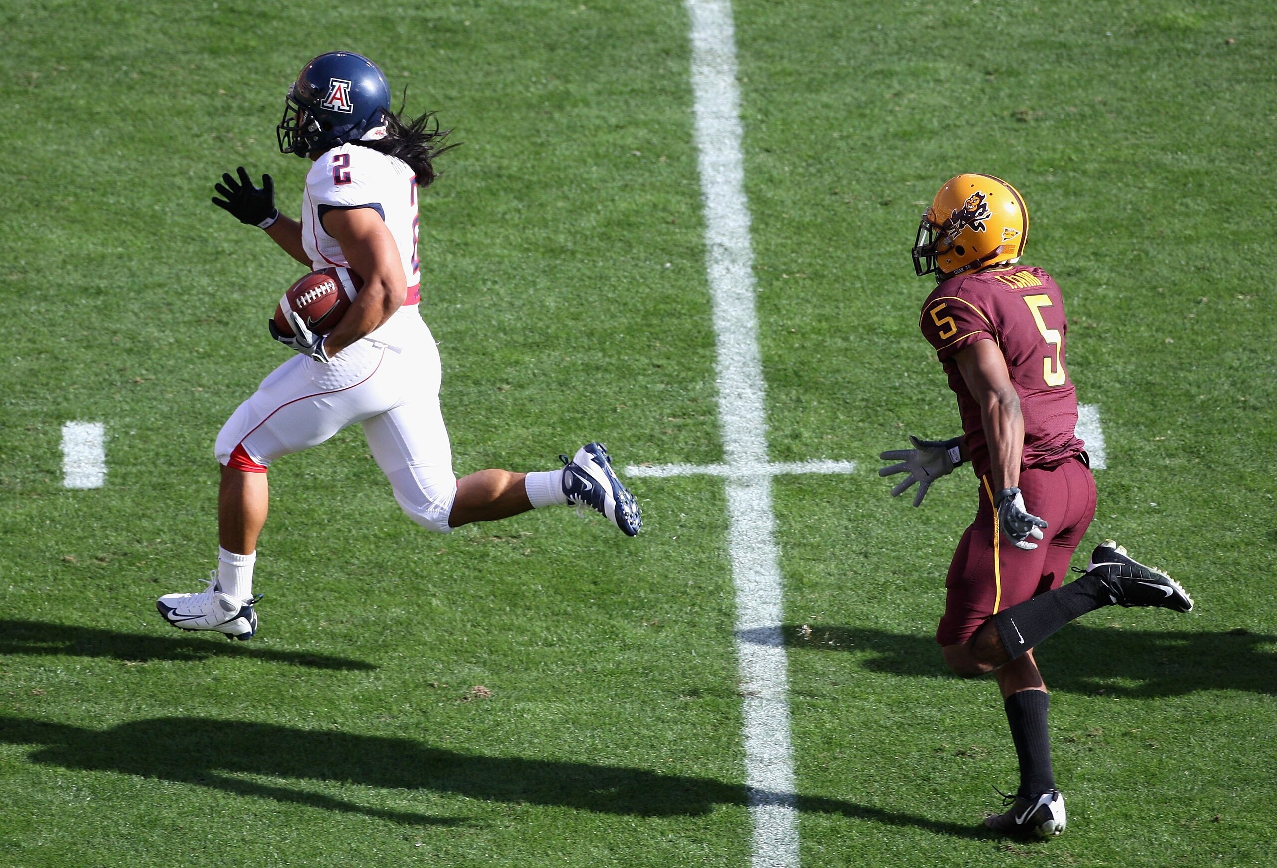 TEMPE, AZ - NOVEMBER 28:  Wide reciver Keola Antolin #2 of the Arizona Wildcats rushes for a 68 yard touchdown past Terell Carr #5 of the Arizona State Sun Devils during the college football game at Sun Devil Stadium on November 28, 2009 in Tempe, Arizona