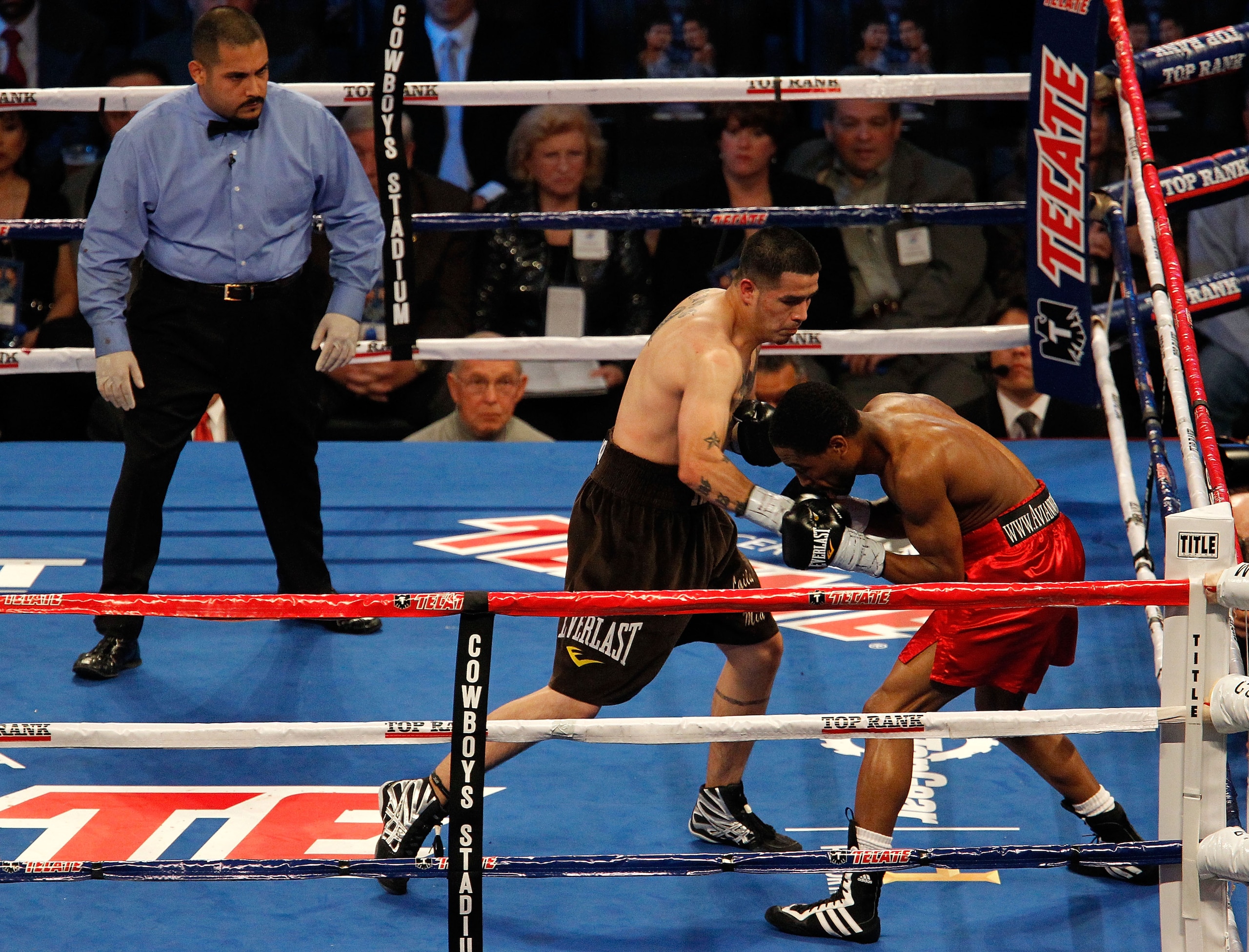 ARLINGTON, TX - NOVEMBER 13:  Brandon Rios (L in brown trunks) lands a punch against Omri Lowther (red trunks) as referee Raul Caiz Jr. looks on during their Super Lightweight bout at Cowboys Stadium on November 13, 2010 in Arlington, Texas.  (Photo by To