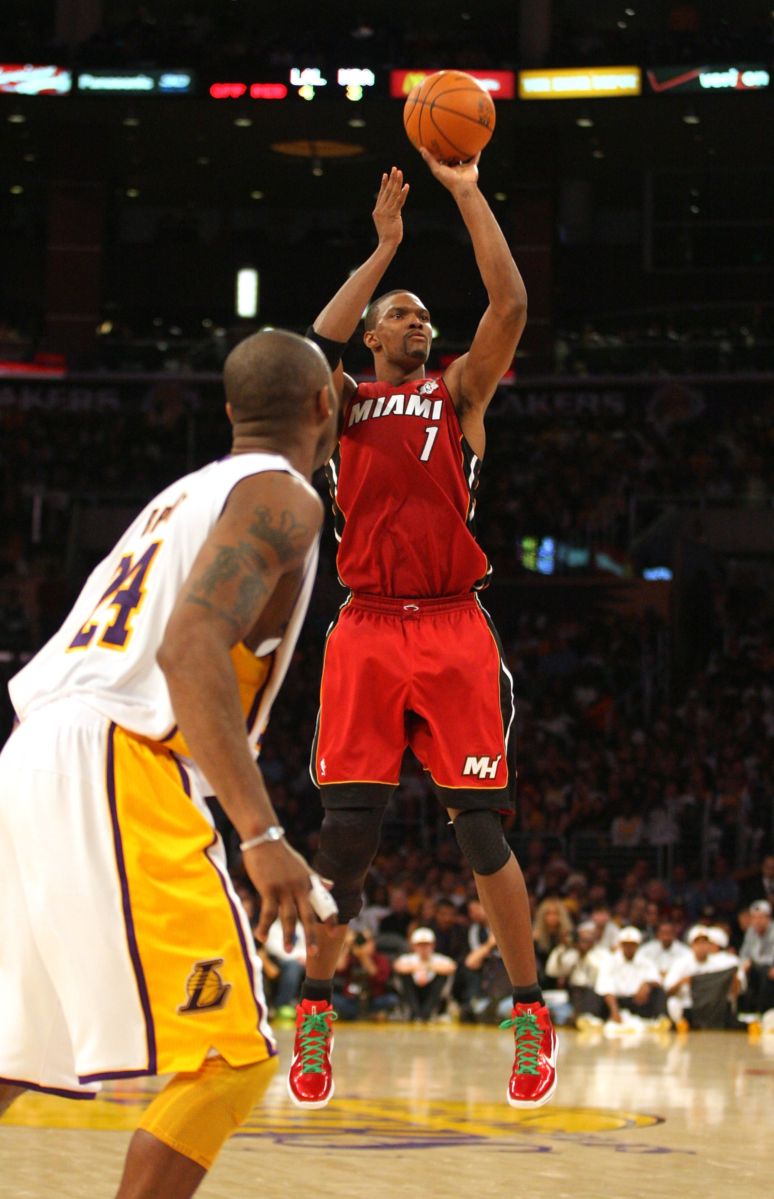 LOS ANGELES, CA - DECEMBER 25: Chris Bosh #1 of the Miami Heat shoots a jump shot as Kobe Bryant #24 of the Los Angeles Lakers looks on during the NBA game at Staples Center on December 25, 2010 in Los Angeles, California. (Photo by Victor Decolongon/Gett