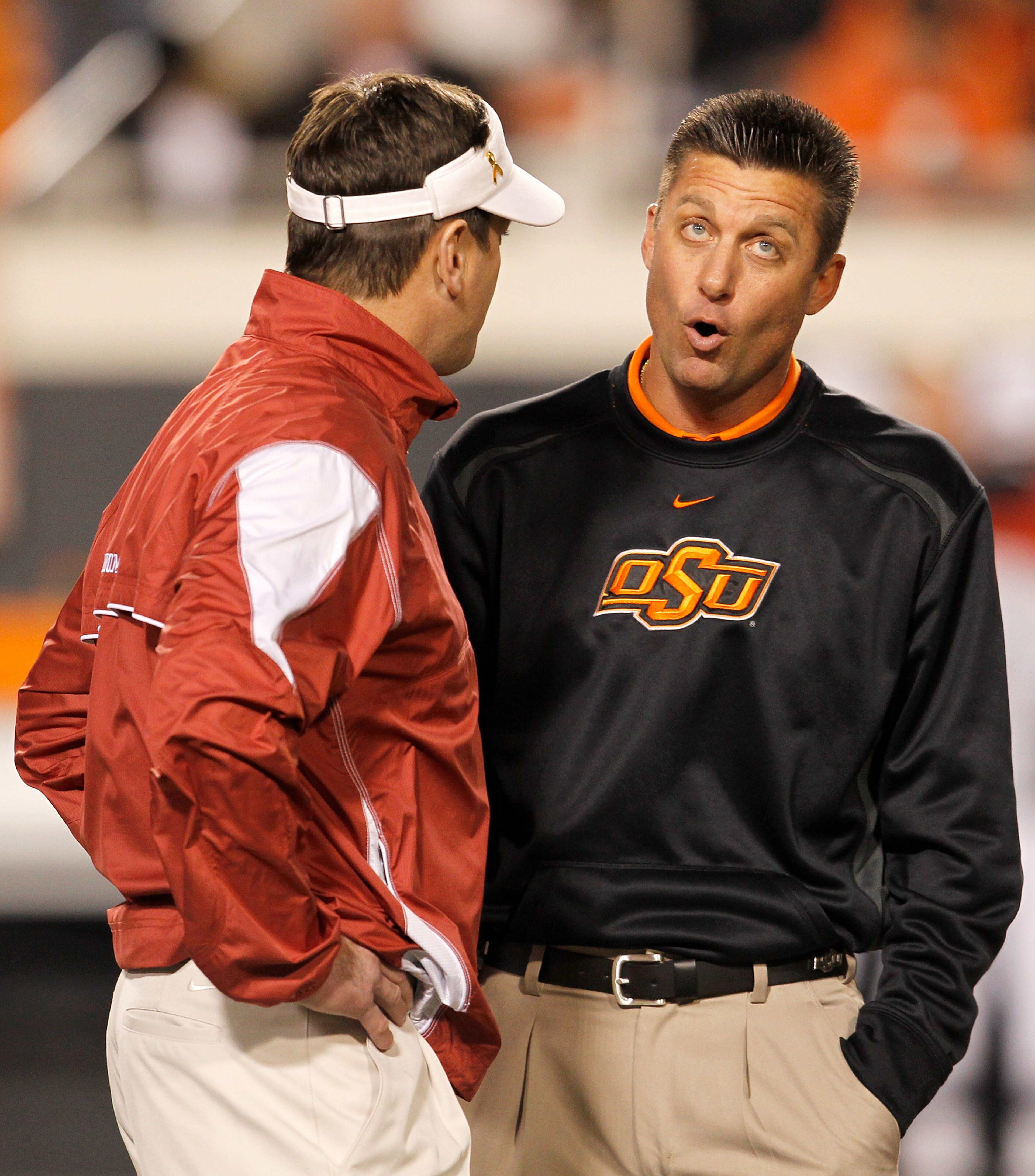 STILLWATER, OK - NOVEMBER 27:  Head coach Bob Stoops (L) of the Oklahoma Sooners talks with head coach Mike Gundy (R) of the Oklahoma State Cowboys at Boone Pickens Stadium on November 27, 2010 in Stillwater, Oklahoma.  (Photo by Tom Pennington/Getty Imag