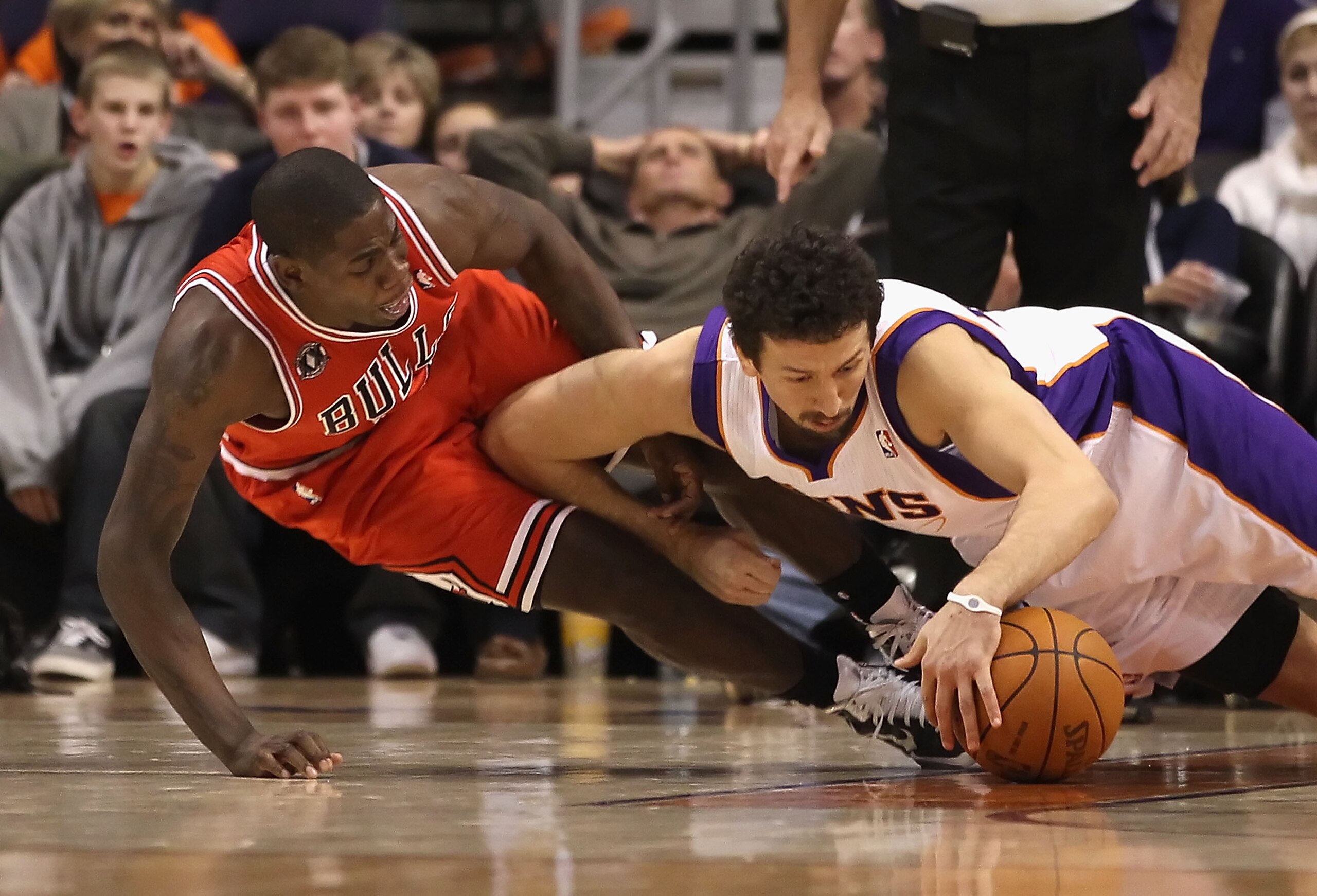 PHOENIX - NOVEMBER 24:  Hedo Turkoglu  #19 of the Phoenix Suns dives for a loose ball with Ronnie Brewer #11 of the Chicago Bulls during the NBA game at US Airways Center on November 24, 2010 in Phoenix, Arizona. NOTE TO USER: User expressly acknowledges